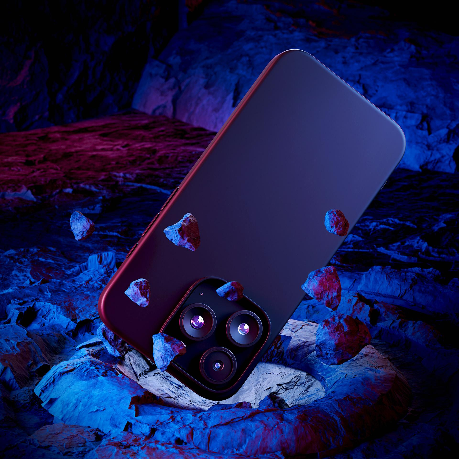 Granatowy telefon otoczony jest małymi kamieniami na teksturowanej, kolorowej powierzchni.