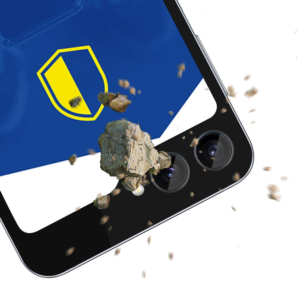 Ekran telefonu z żółto-niebieskim wzorem tarczy jest uderzany przez kamień, co demonstruje jego trwałość.