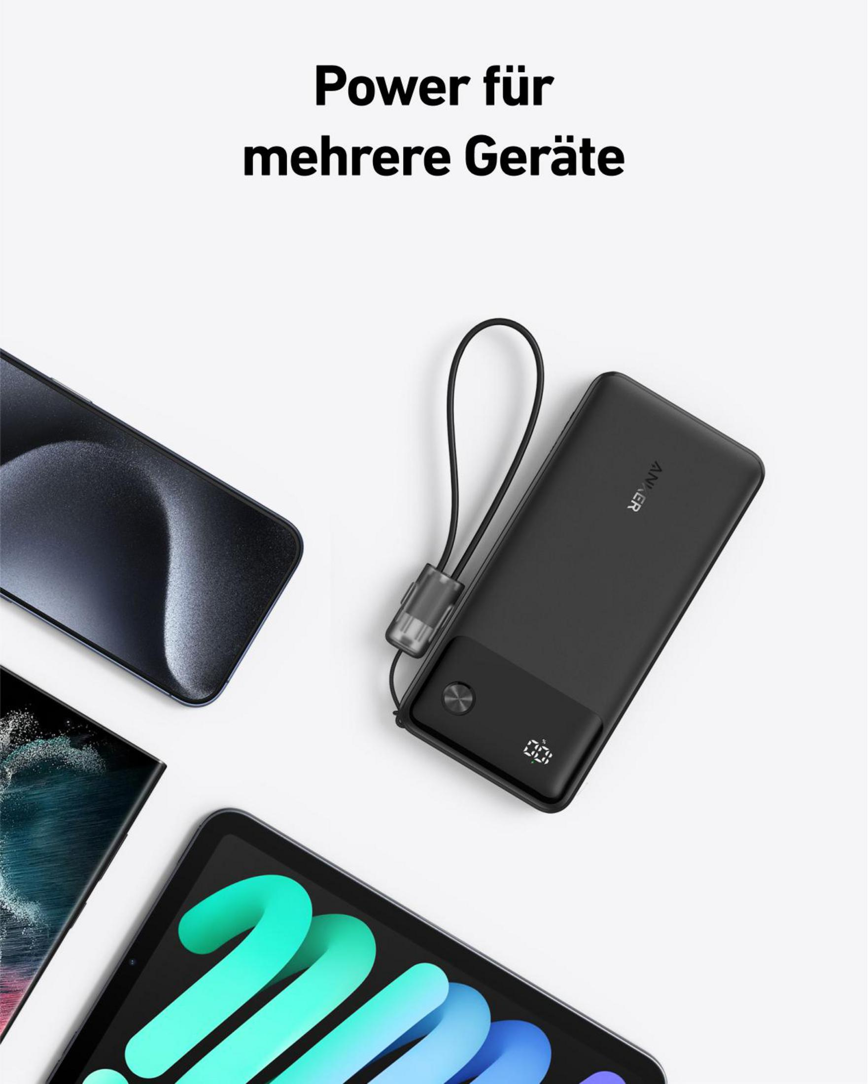 Un power bank nero si trova tra un telefono e un tablet su uno sfondo bianco, con un anello di ricarica.