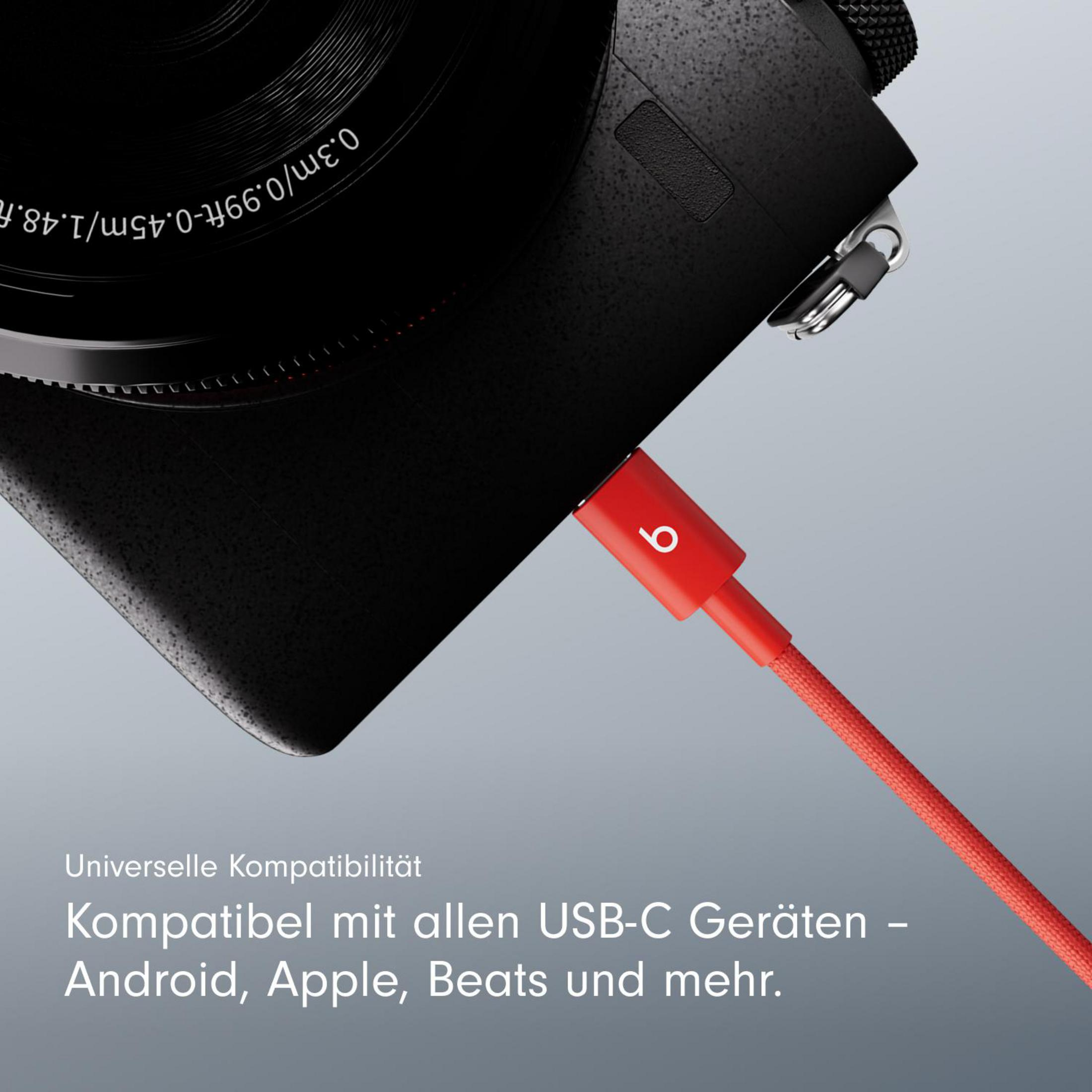 Eine schwarze Kamera ist mit einem roten USB-C-Kabel mit Beats-Logo verbunden. Kompatibilität.