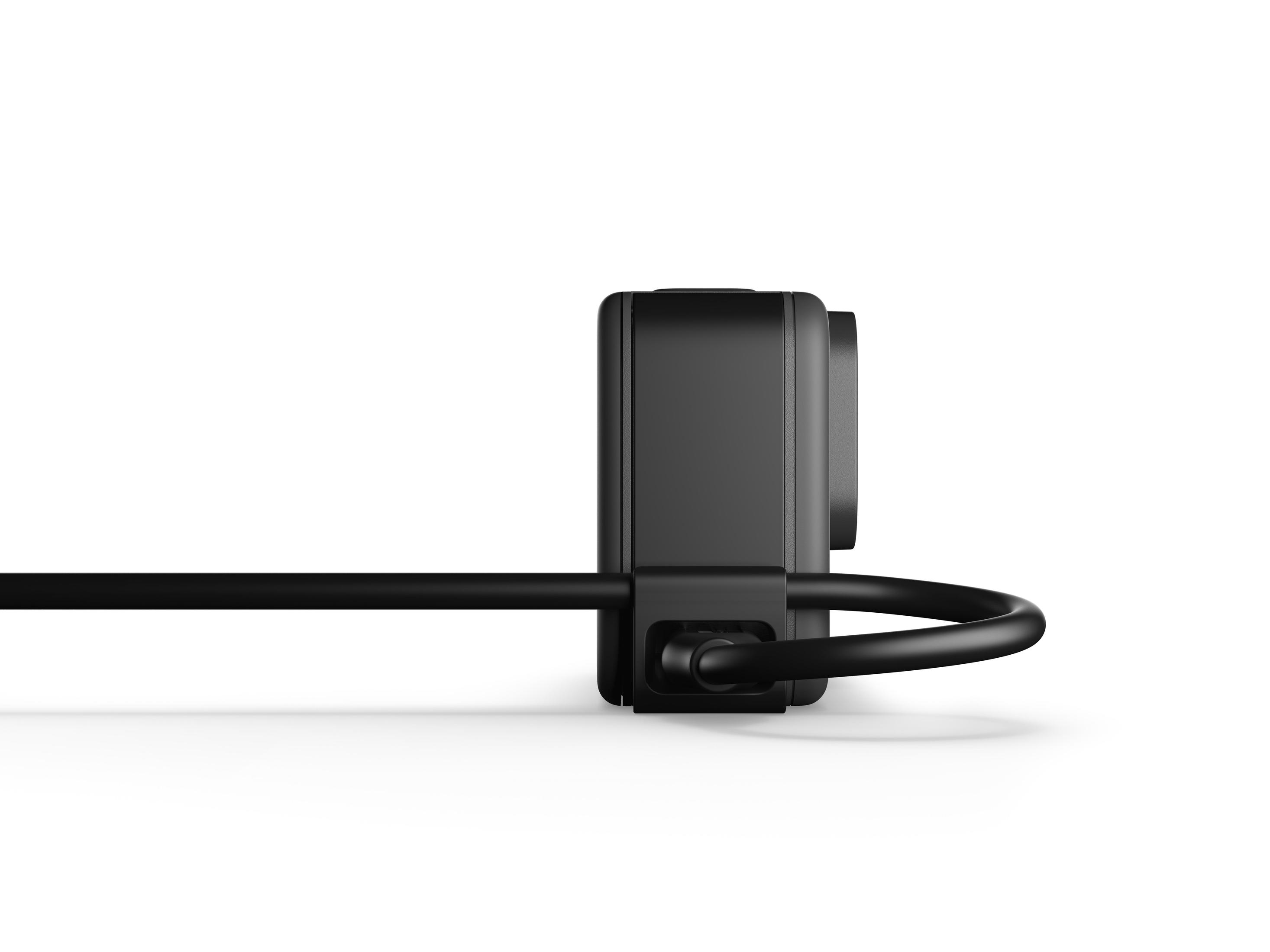 Eine schwarze Action-Kamera ist an ein schwarzes Kabel angeschlossen, von der Seite betrachtet.