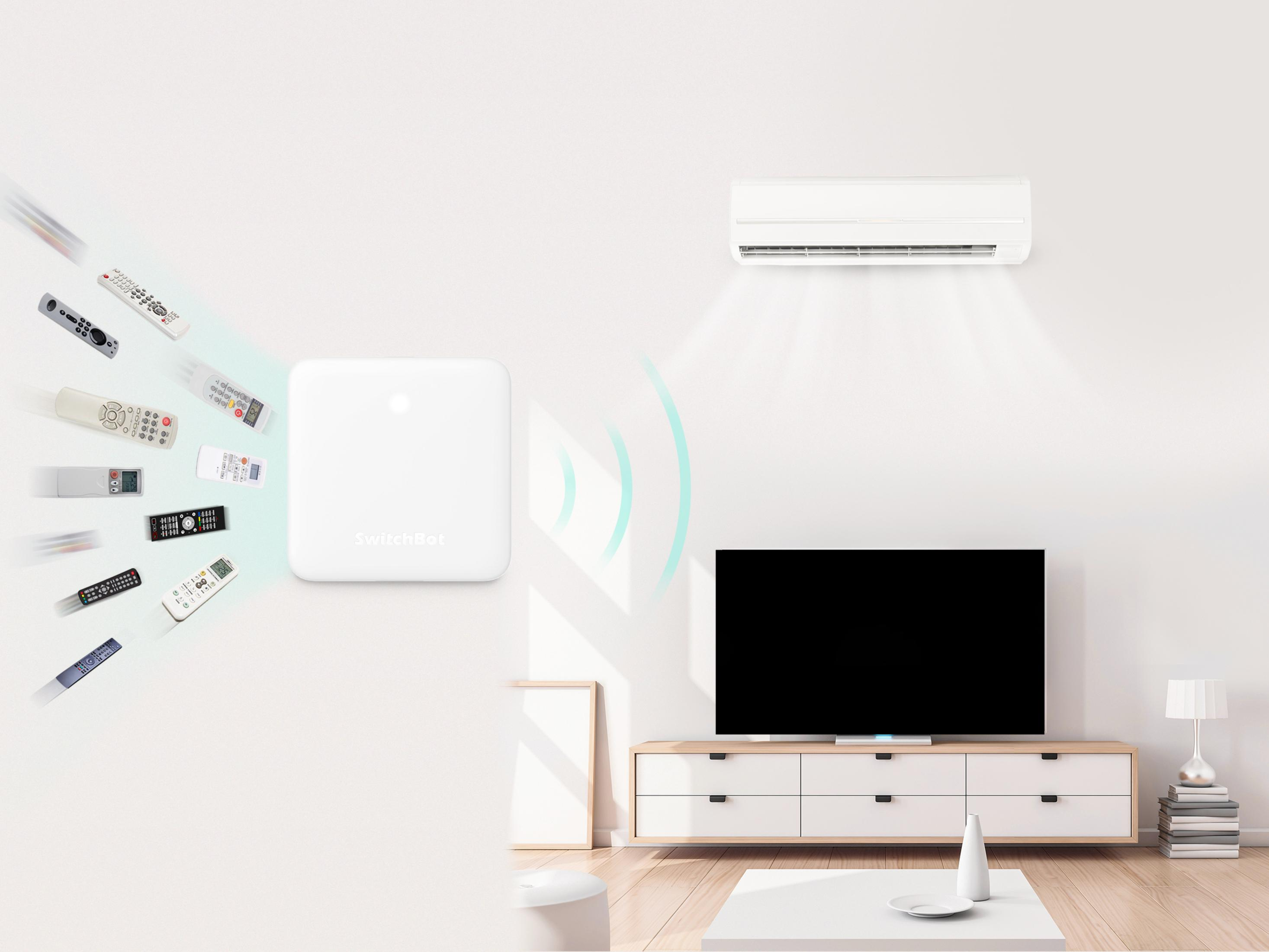 Ein SwitchBot-Hub in einem Wohnzimmer mit einem Fernseher, einer Klimaanlage und mehreren Fernbedienungen.