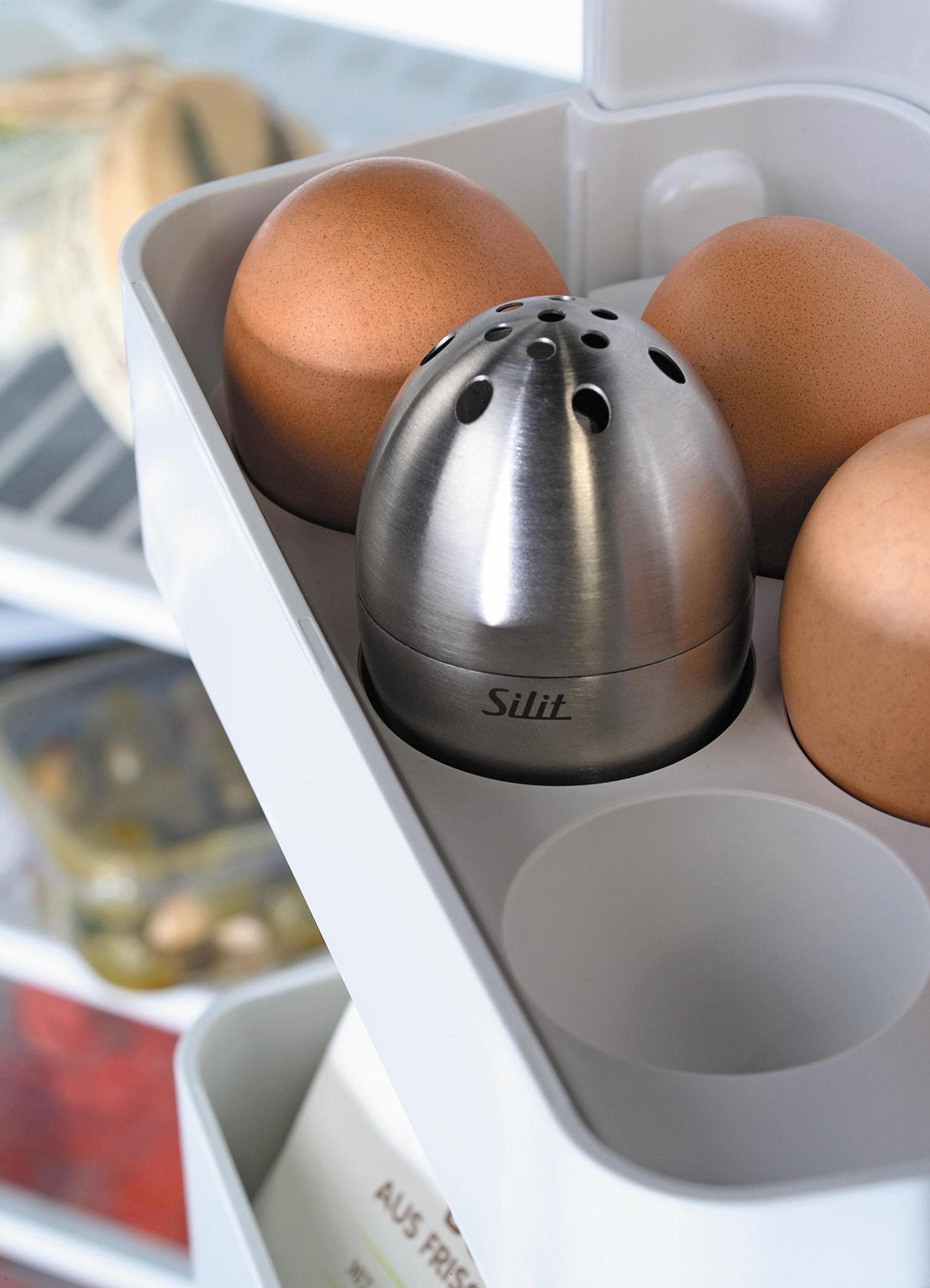 Eier und Silit-Eierhalter in einem Kühlschrank. Weiße und silberne Töne dominieren das Bild.