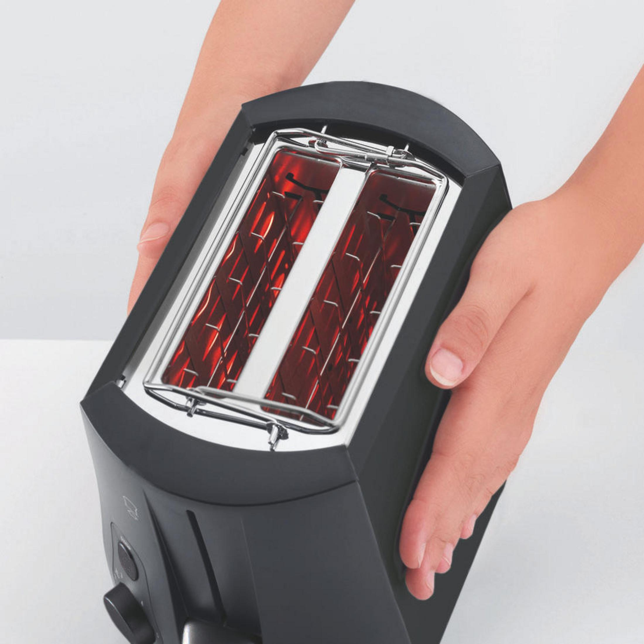 Hände, die einen schwarzen Toaster mit rot glühenden Heizelementen halten, vor einem weißen Hintergrund.