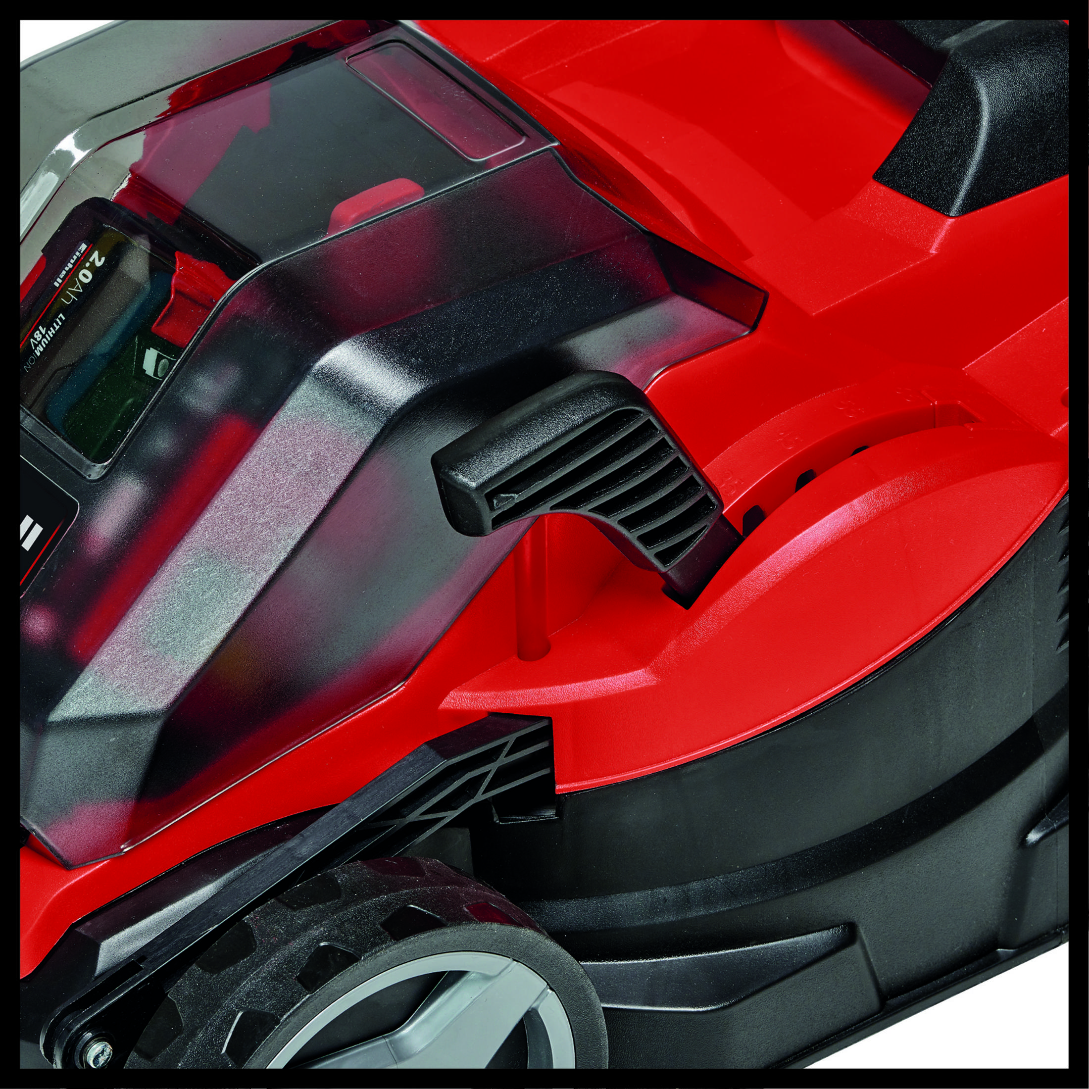 Nahaufnahme eines rot-schwarzen Rasenmähers. Der Fokus liegt auf den Kunststoffteilen des Rasenmähers.
