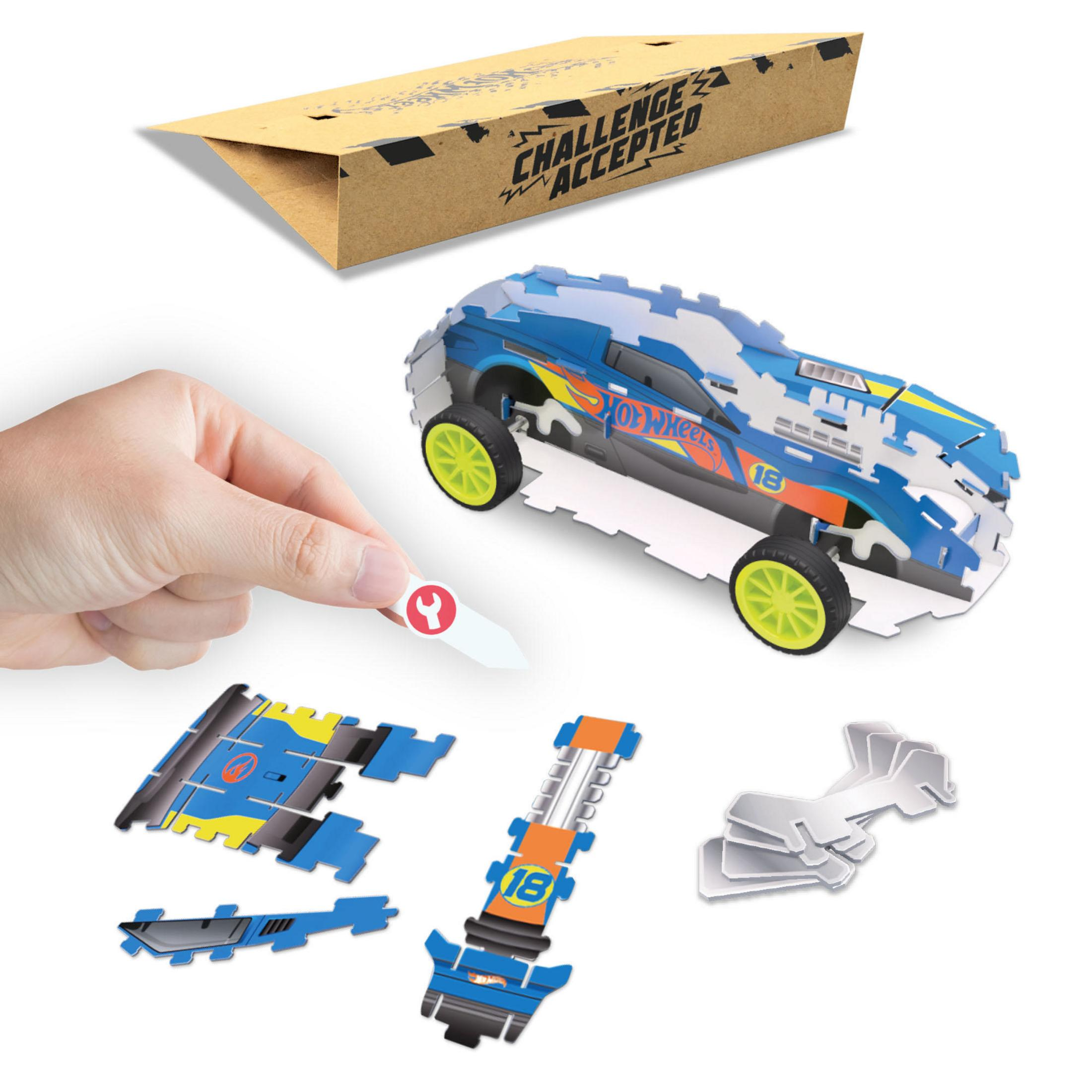 Ein zerlegtes Hot Wheels Auto mit Stuntrampe und Zubehör auf weißem Hintergrund.