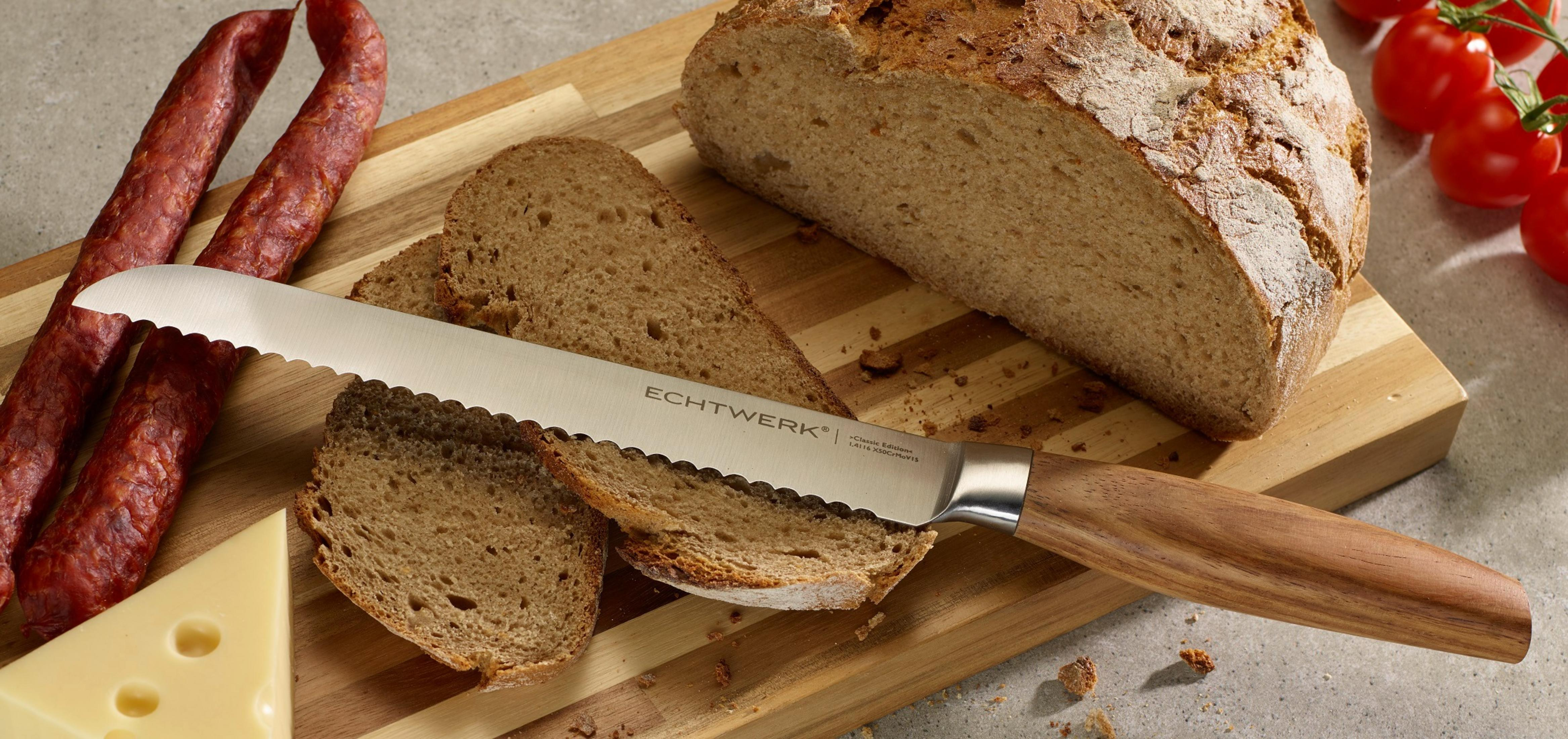 Echtwerk Brotmesser schneidet Brot auf einem Holzbrett mit Wurst und Käse.