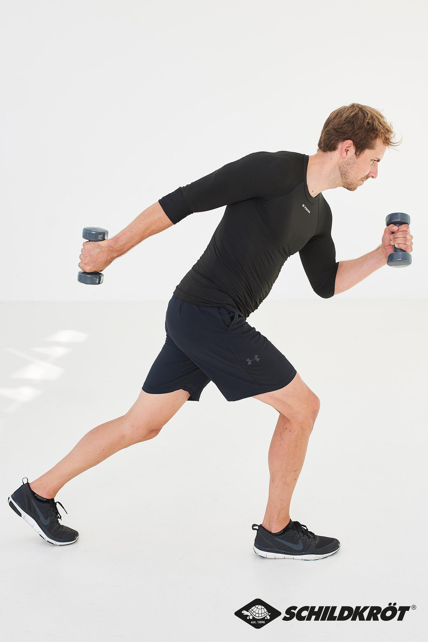 Uomo in abbigliamento sportivo che fa affondi con i manubri su uno sfondo bianco.