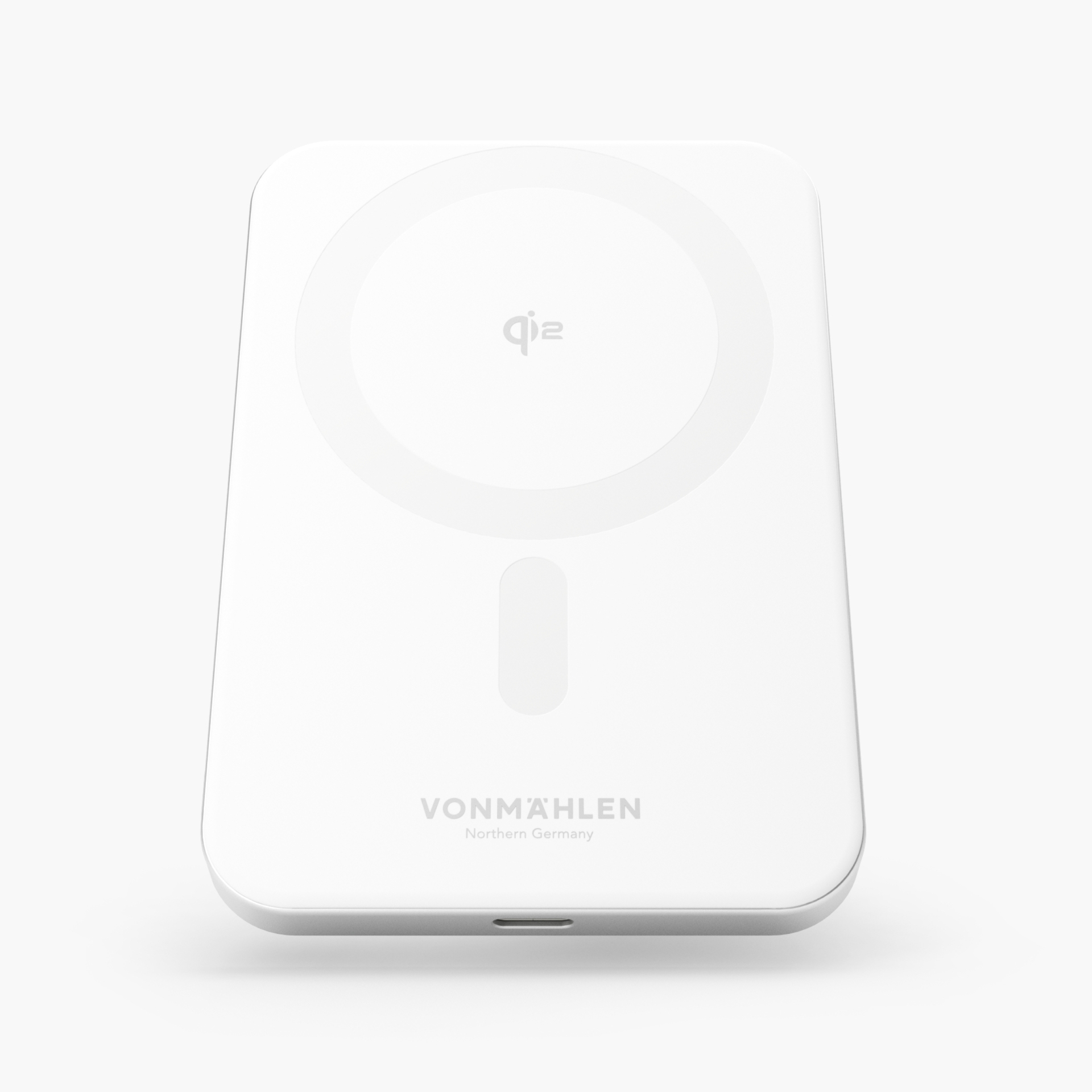 Un caricabatterie wireless bianco etichettato VONMAHLEN con un cerchio al centro e una porta USB nella parte inferiore.