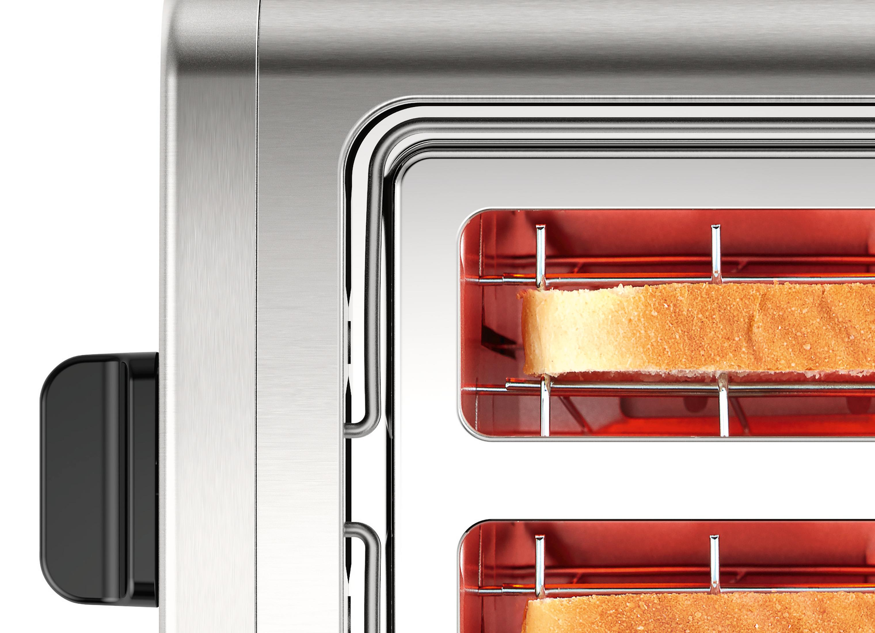 Close up of a toaster with bread inside the slots. The toaster is silver and has a black top.