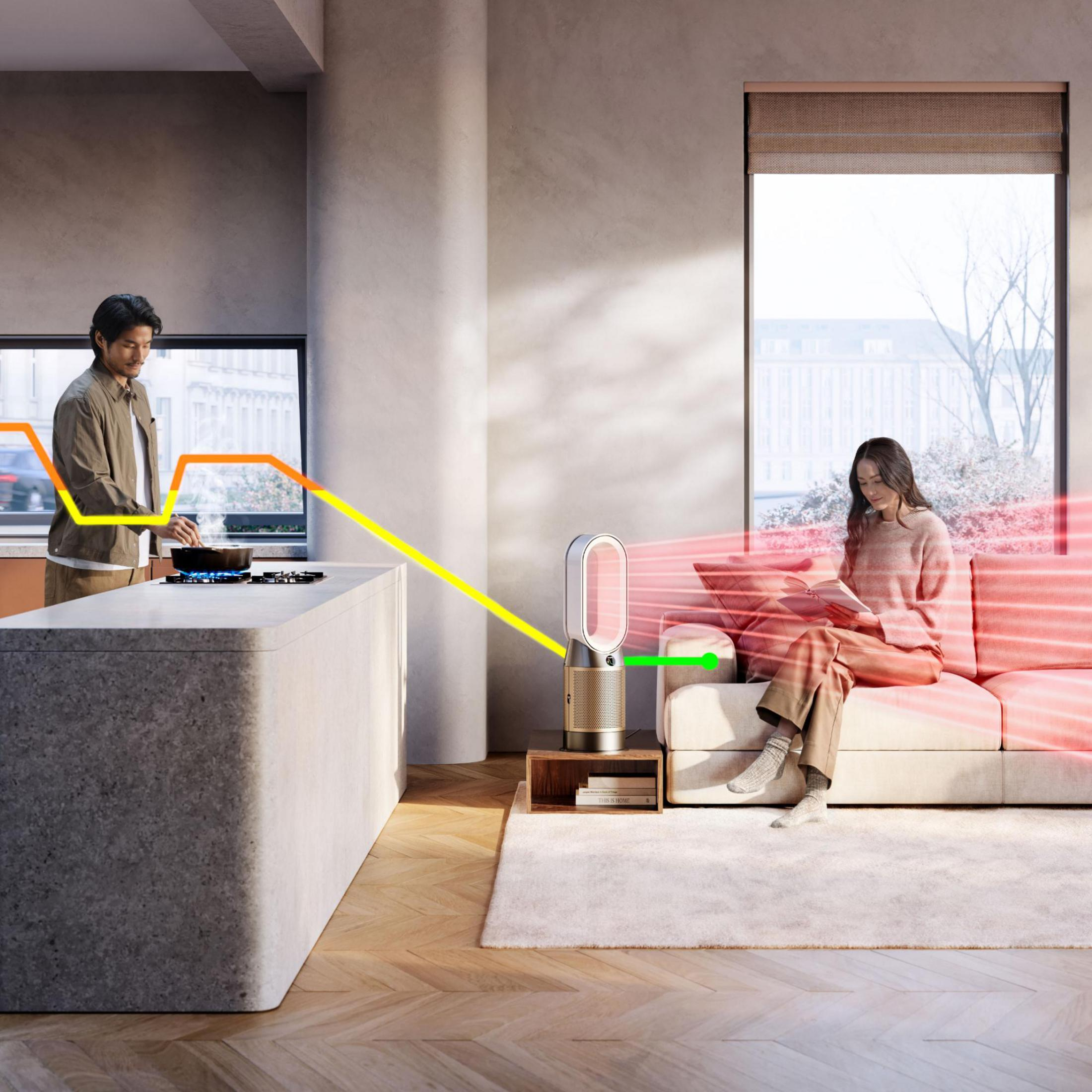 Soggiorno con una donna che legge su un divano, un uomo che cucina e un purificatore Dyson nel mezzo.