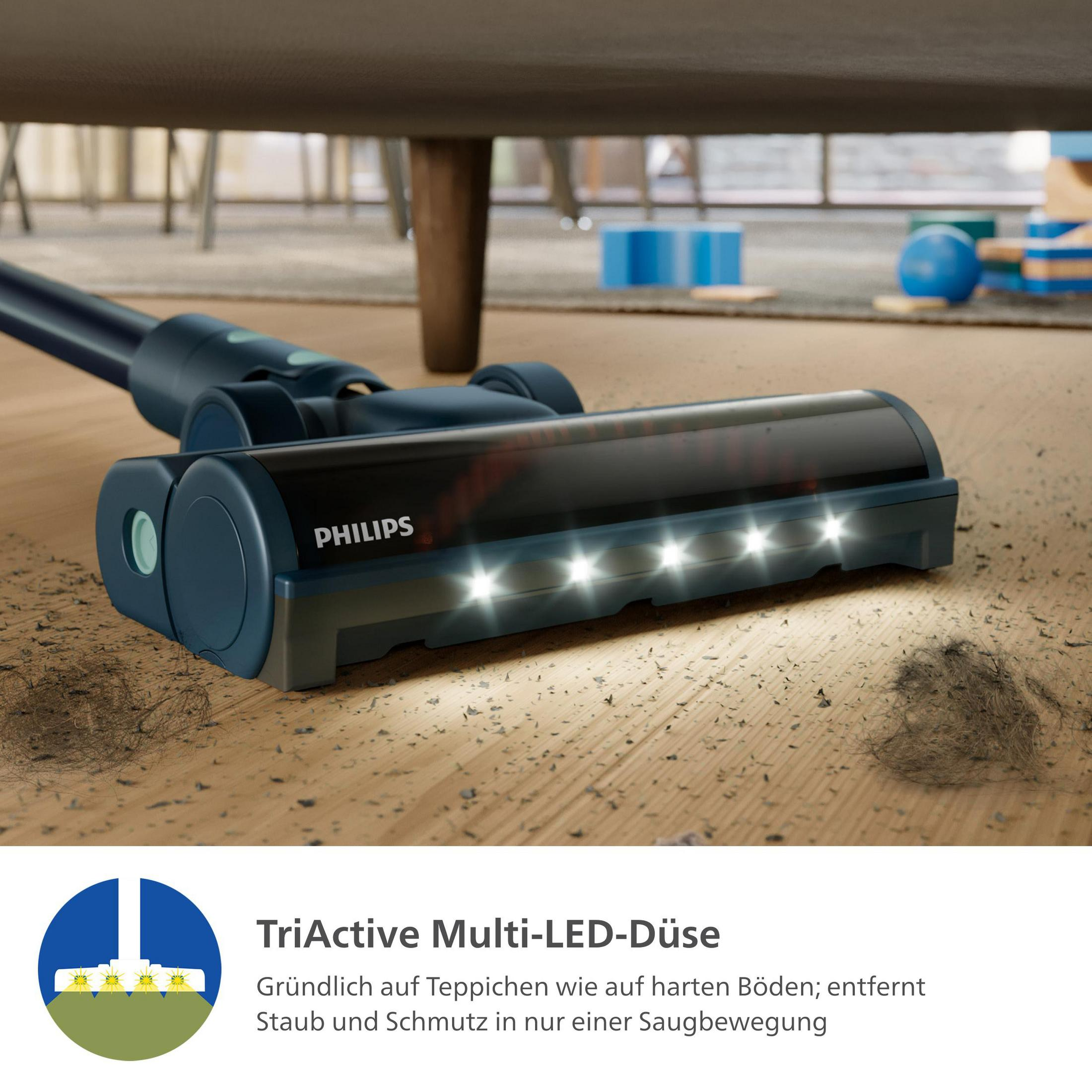 L'aspirapolvere pulisce un pavimento. Capelli neri e sporco sul pavimento. L'aspirapolvere ha luci a LED.