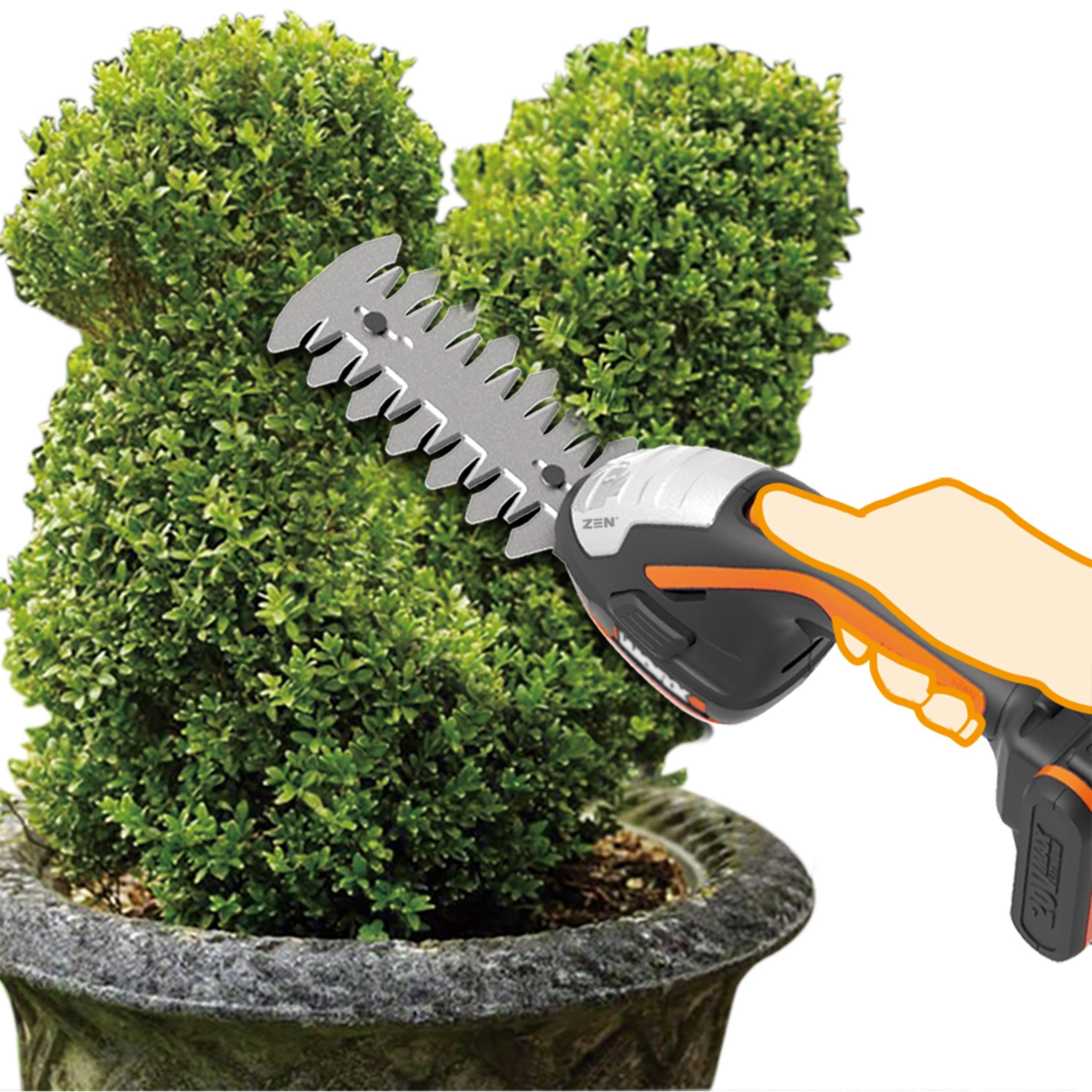Ein WORX-Grastrimmer, der einen Busch in einem Topf schneidet.