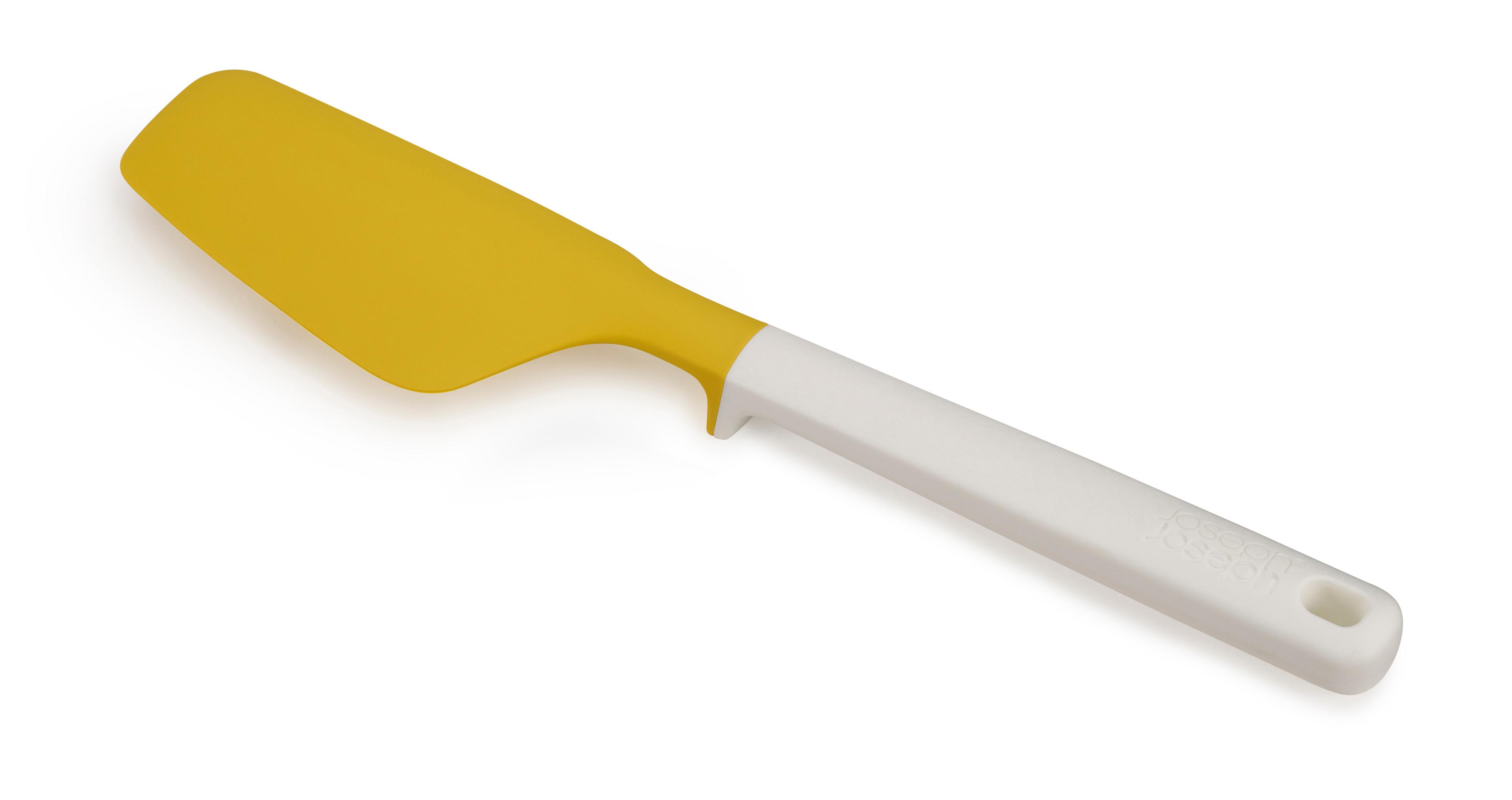 Beyaz zemin üzerinde sarı ve beyaz spatula. Spatula açılı, sap sağa doğru.