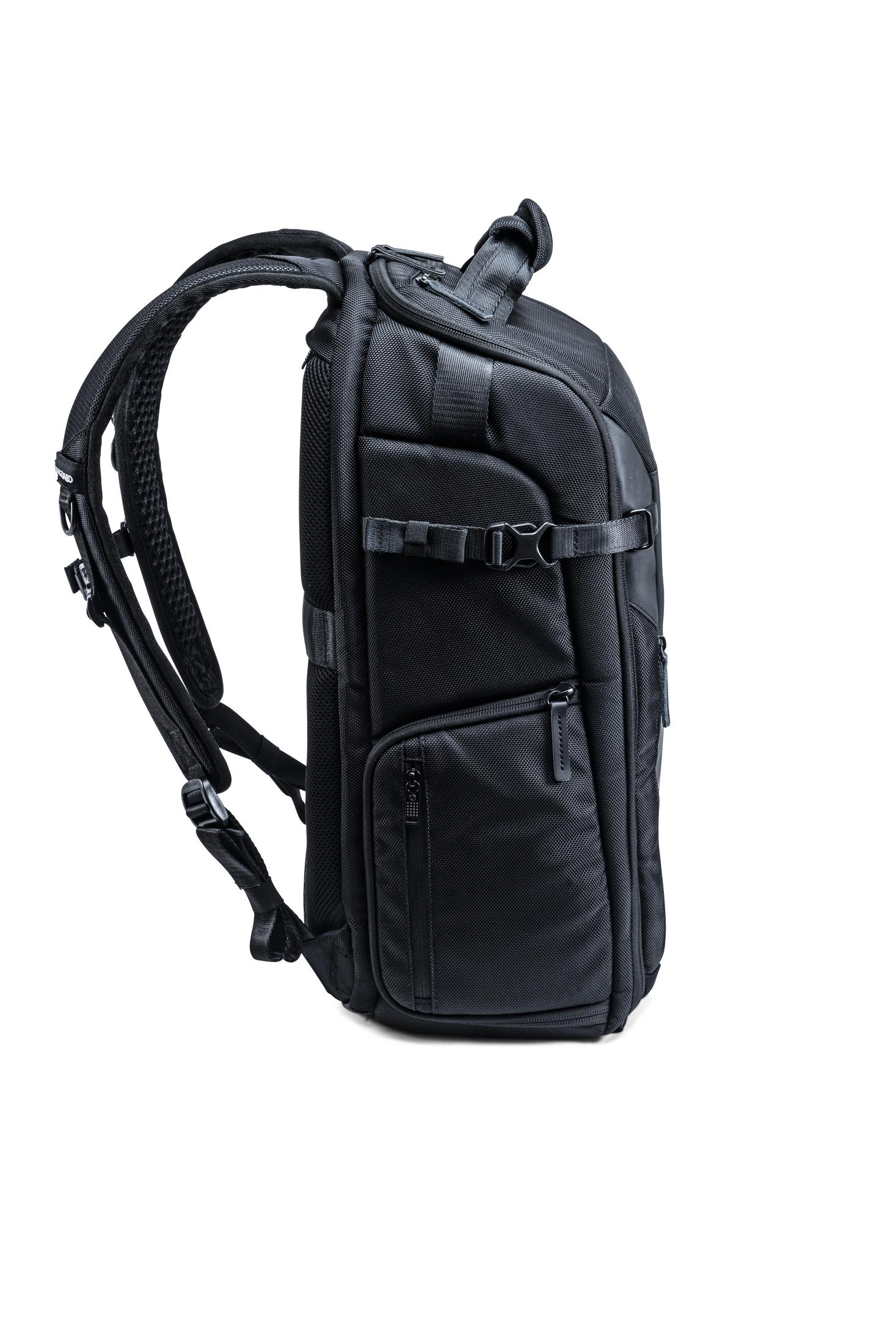 Schwarzer Rucksack von der Seite, mit Riemen und Taschen. Er befindet sich auf weißem Hintergrund.
