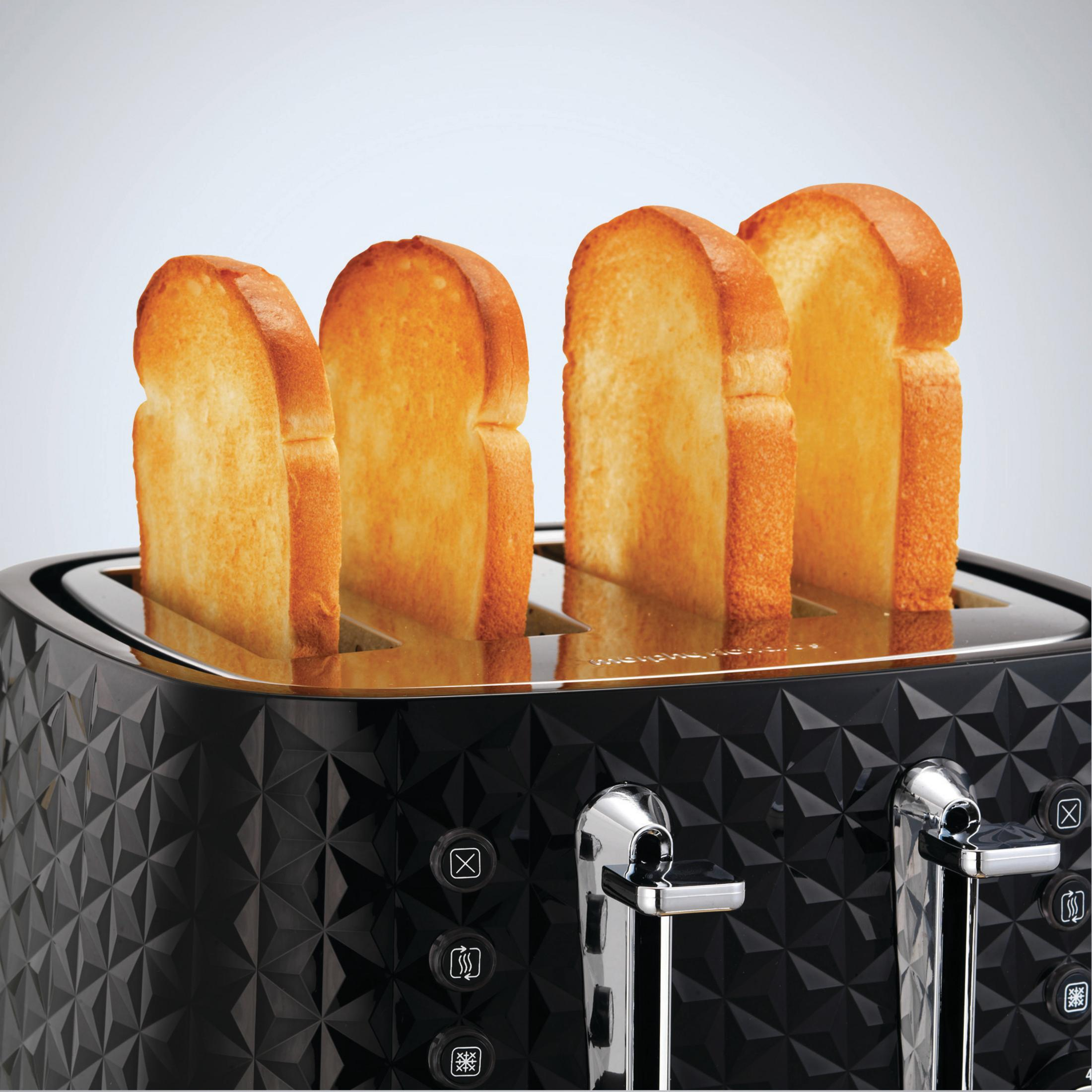 Quattro fette di pane tostato in un tostapane nero a quattro fette con motivo geometrico.