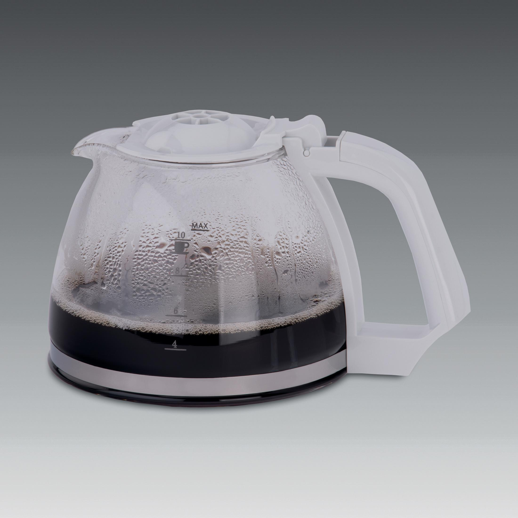 Eine Glaskaraffe mit weißem Griff und Deckel, gefüllt mit dunklem Kaffee. Kondensation auf dem Glas.