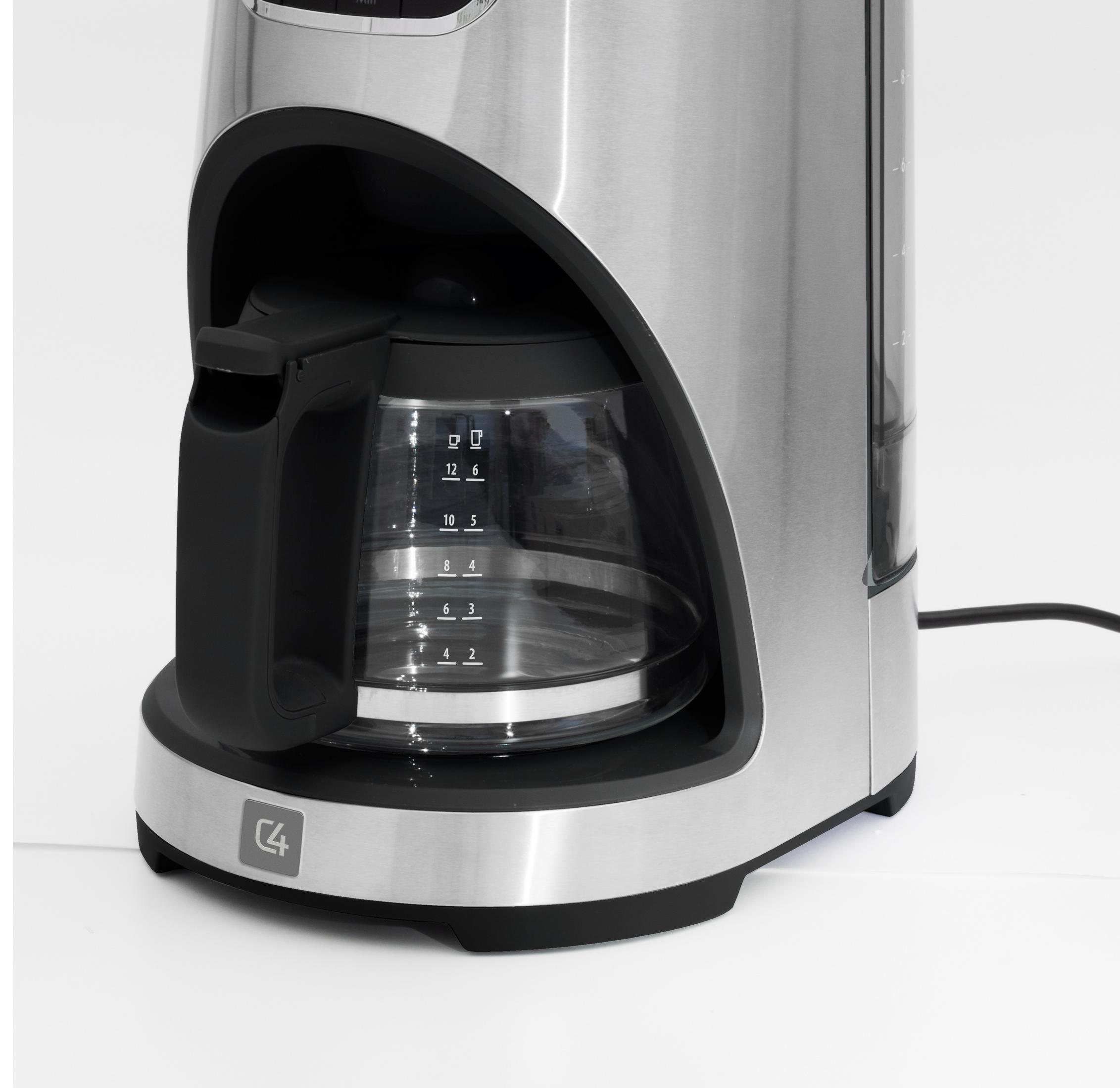 Una macchina da caffè argentata con una caraffa di vetro che mostra il livello dell'acqua su uno sfondo bianco.
