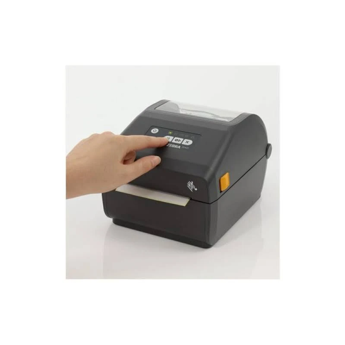 Una mano preme un pulsante su una stampante Zebra grigia con uno sfondo bianco.