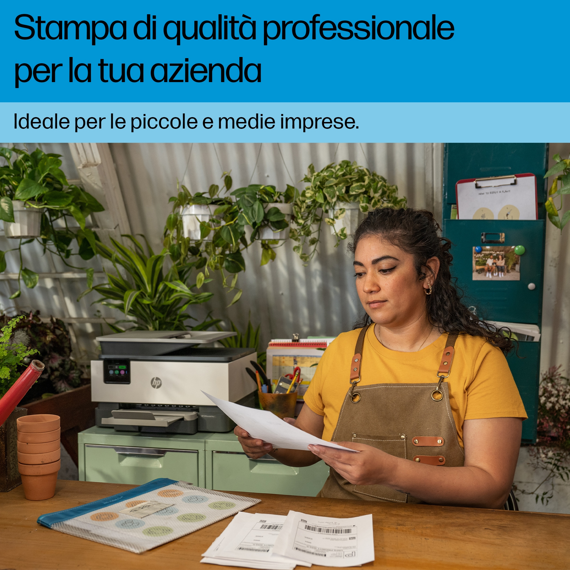 Una donna è in piedi vicino a una stampante HP OfficeJet Pro, tenendo dei documenti tra le mani.