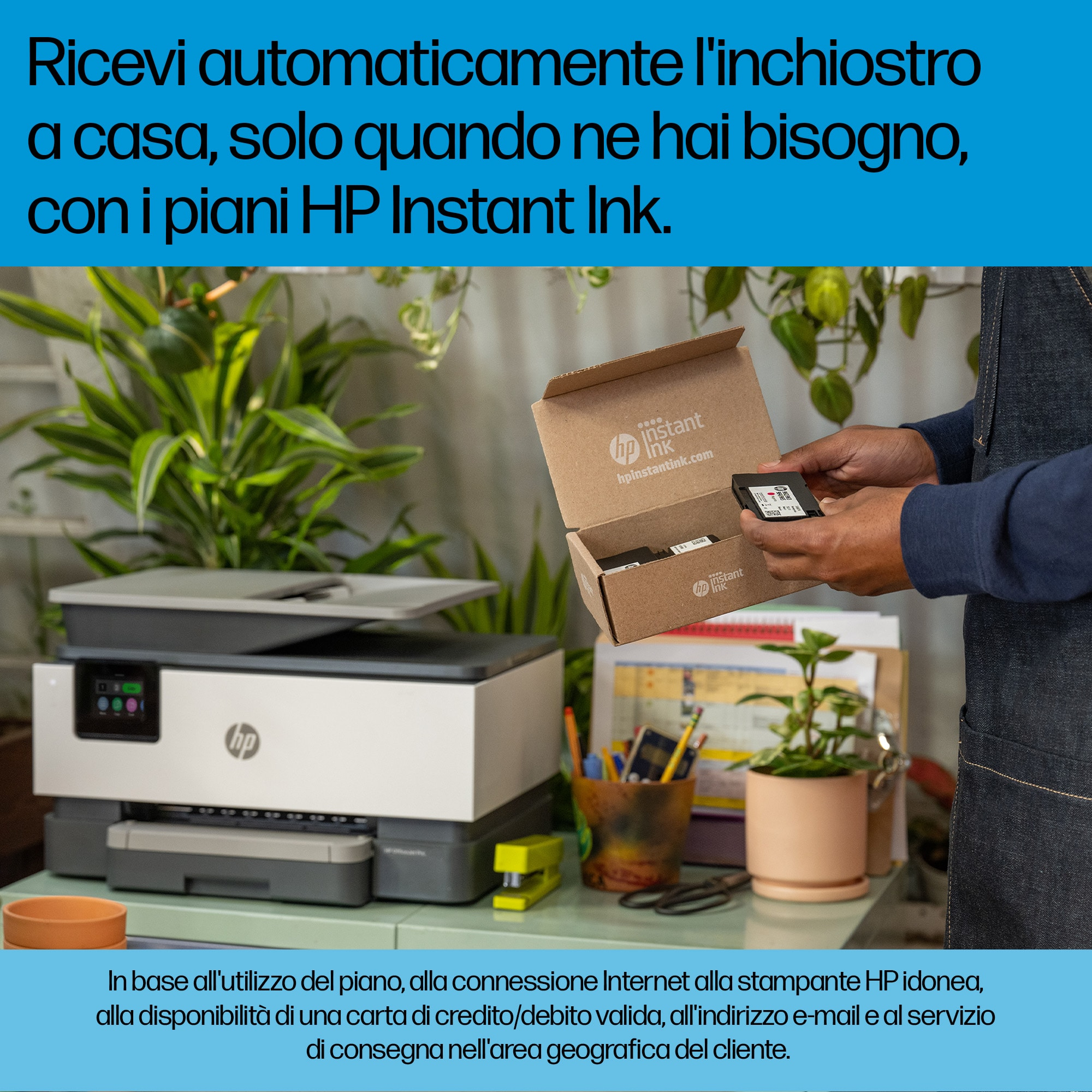 Una stampante HP OfficeJet Pro con una scatola Instant Ink su una scrivania con forniture per ufficio.