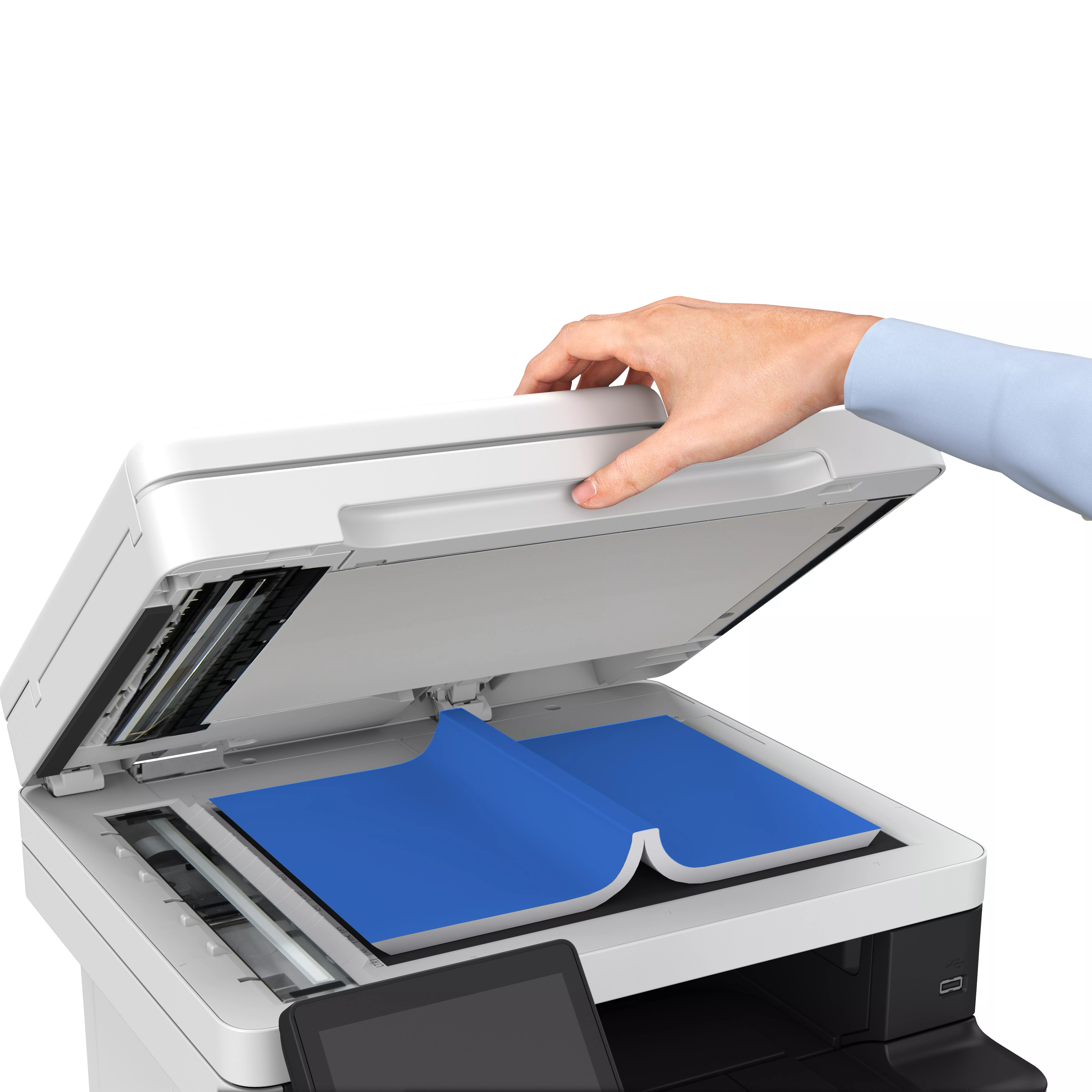 Ręka otwiera pokrywę białej drukarki Canon. W środku jest niebieski papier.