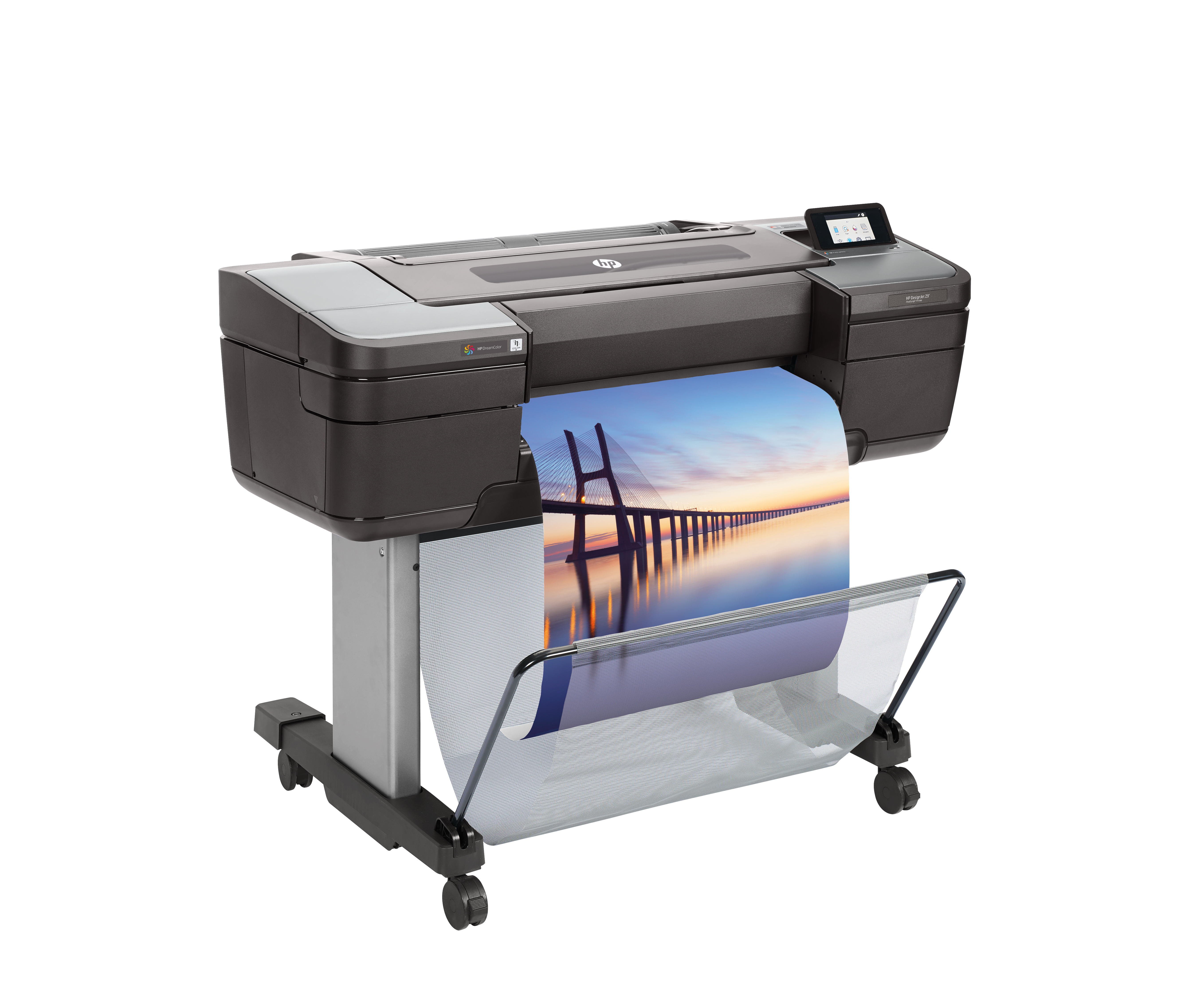 Drukarka wielkoformatowa drukuje obraz mostu o zachodzie słońca. Obraz jest zbierany w koszu z siatki.