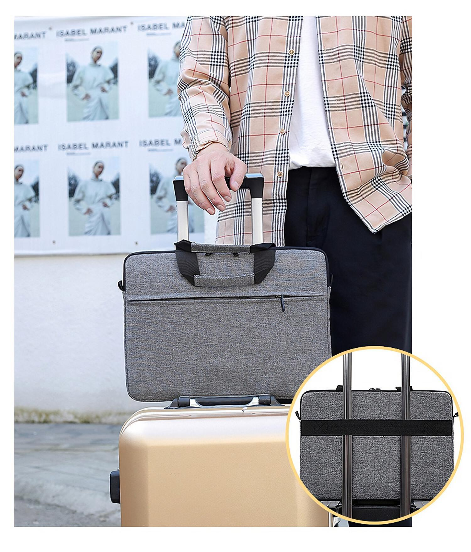 Ein Mann hält eine graue Laptoptasche auf einem goldenen Koffer, mit einem Modeplakat im Hintergrund.