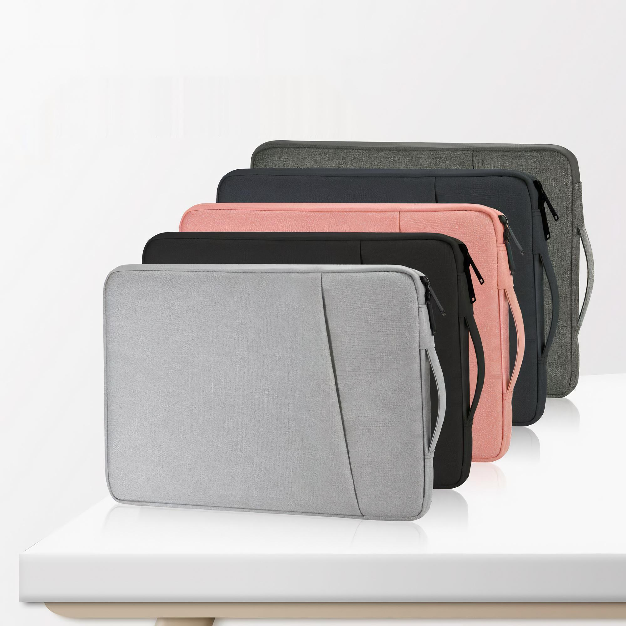 Fünf Laptoptaschen in Grau, Dunkelgrau, Rosa, Schwarz und Hellgrau, die in einer Reihe auf einer weißen Oberfläche stehen.