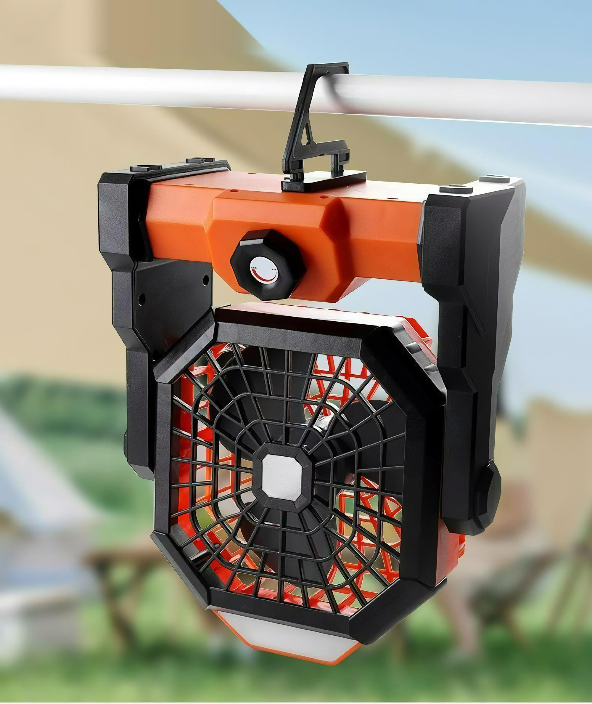 Ein orangefarbener tragbarer Ventilator mit Licht oben hängt an einer weißen Stange.