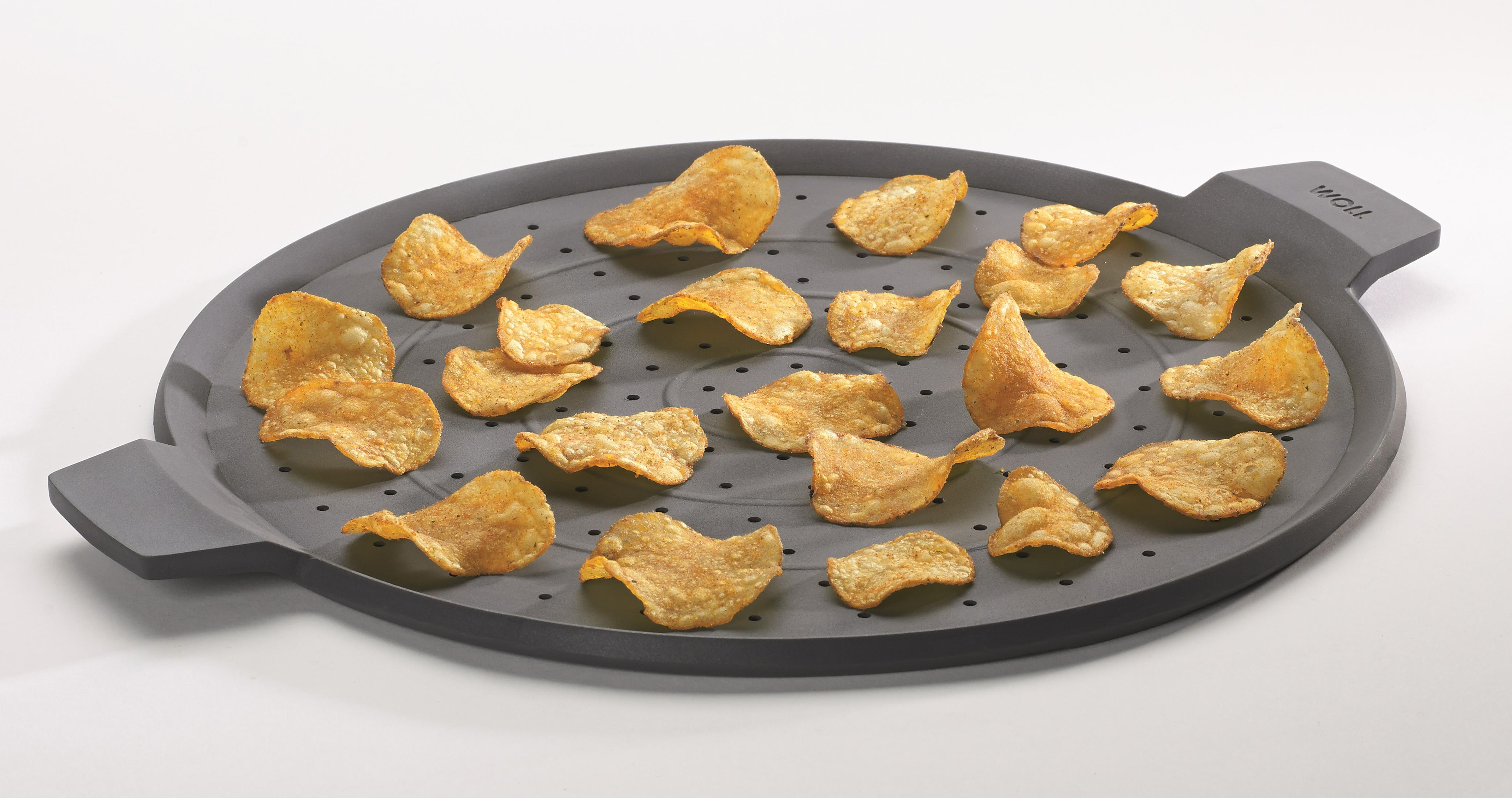 Kartoffelchips, die auf einem grauen Silikon-Spritzschutz kochen, isoliert auf Weiß.