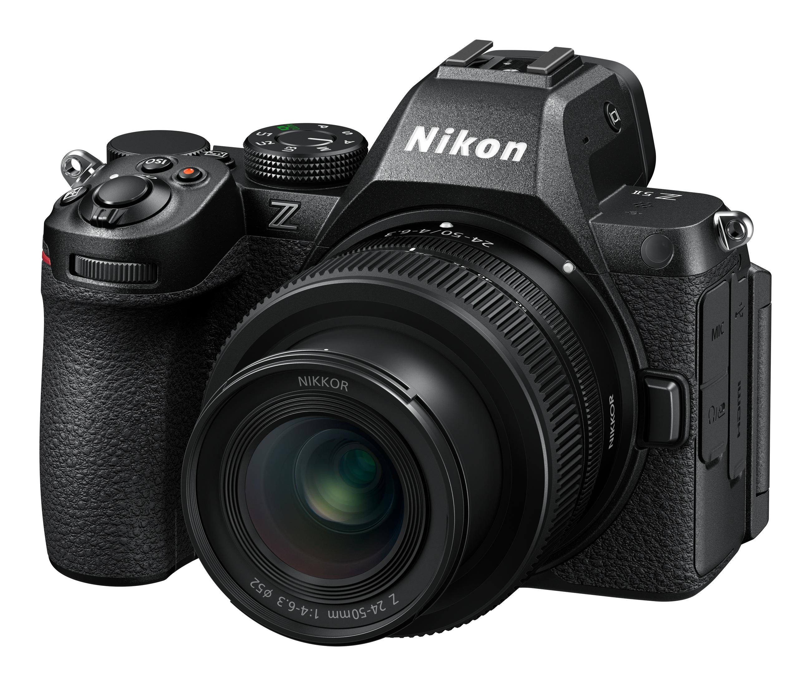 Una cámara Nikon Z 5II negra con un objetivo acoplado se encuentra sobre un fondo blanco en una toma de estudio desde un ángulo alto.