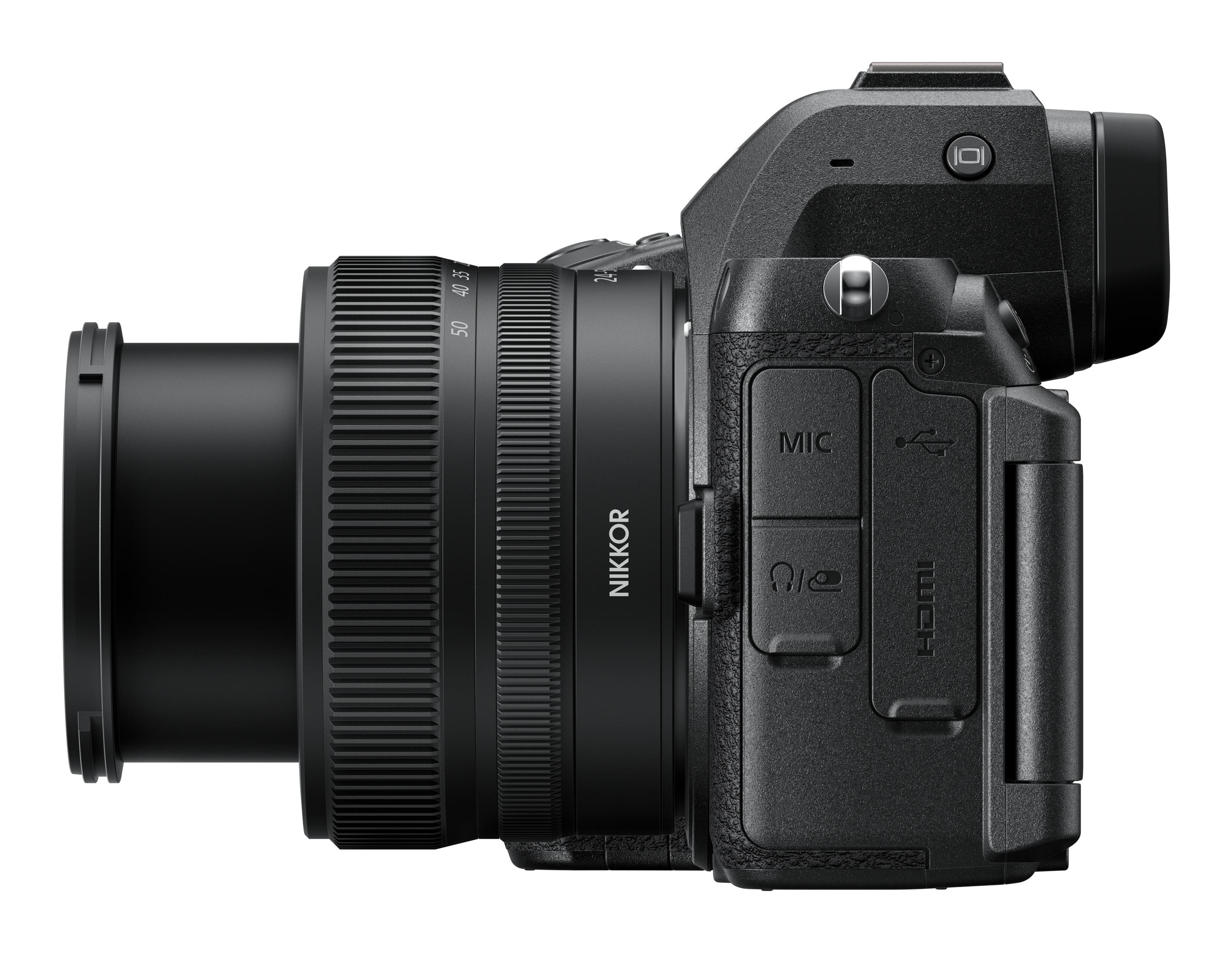Una cámara Nikon Z 5II negra con un objetivo se muestra en una vista lateral sobre un fondo blanco en una toma de estudio.