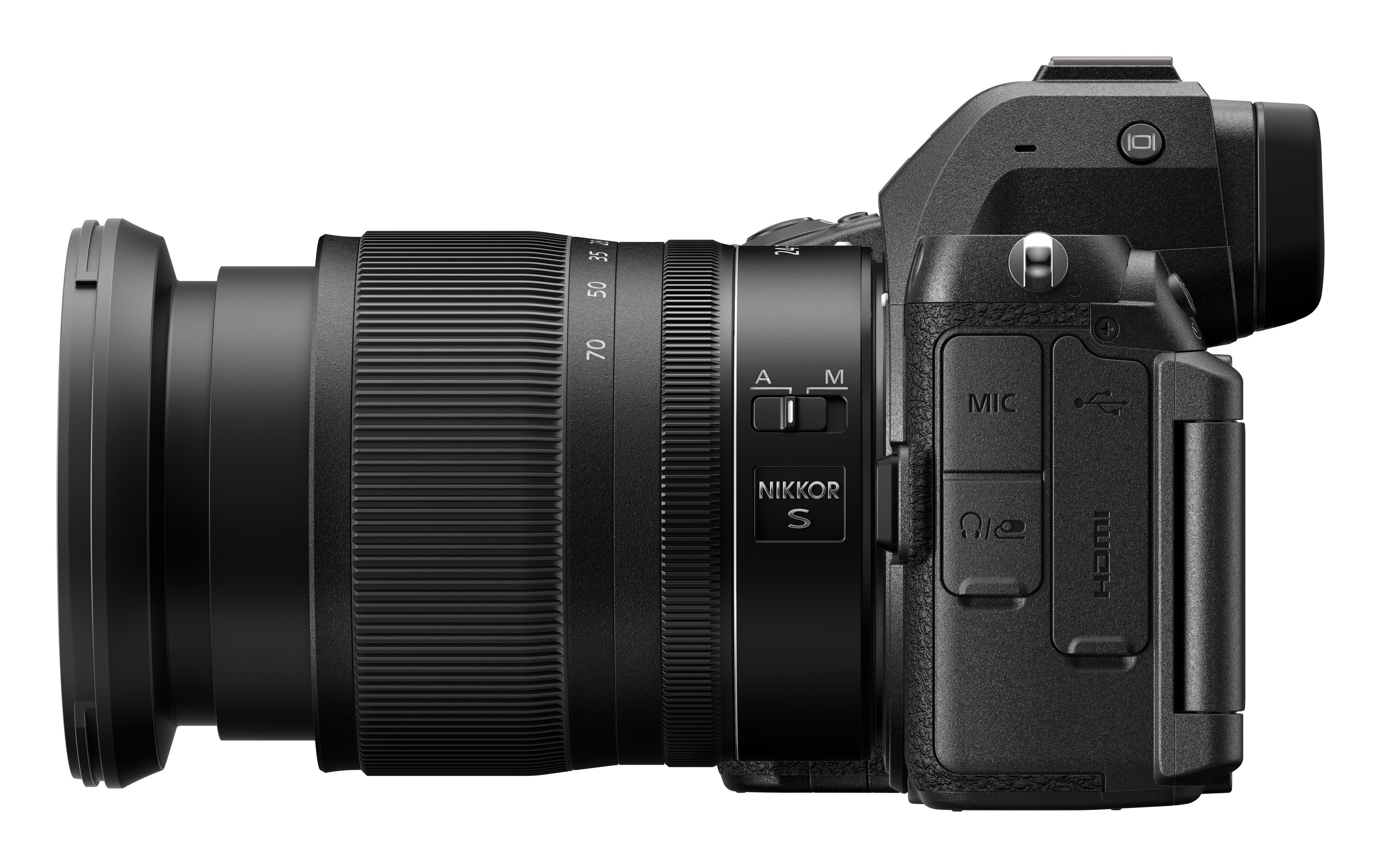 Vista lateral de una cámara Nikon Z negra con lente adjunta. La lente es negra con un anillo plateado.