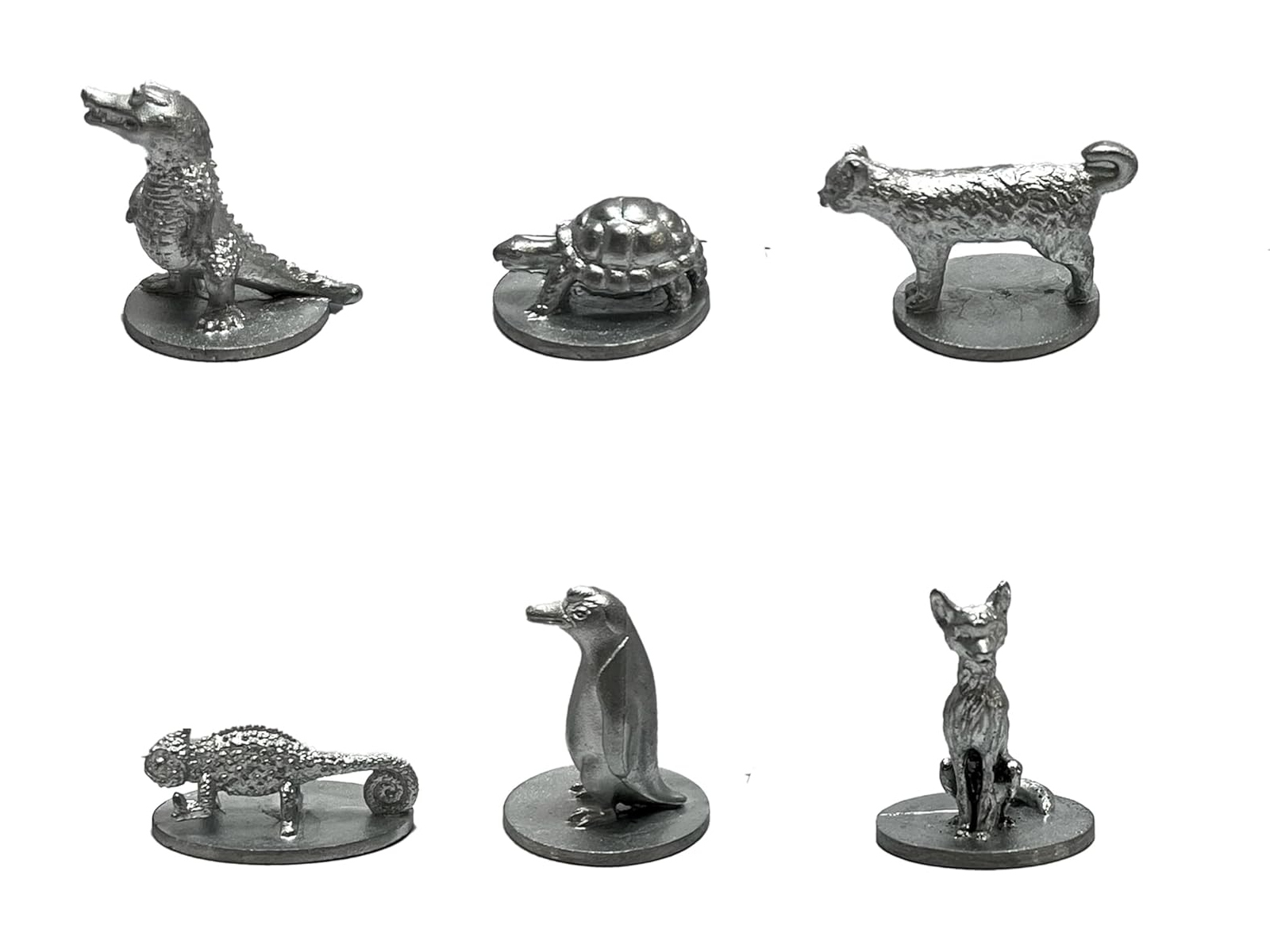Sechs silberfarbene Spielfiguren, darunter ein Krokodil, eine Schildkröte, eine Katze, ein Chamäleon, ein Pinguin und ein Fuchs, auf weißem Hintergrund.