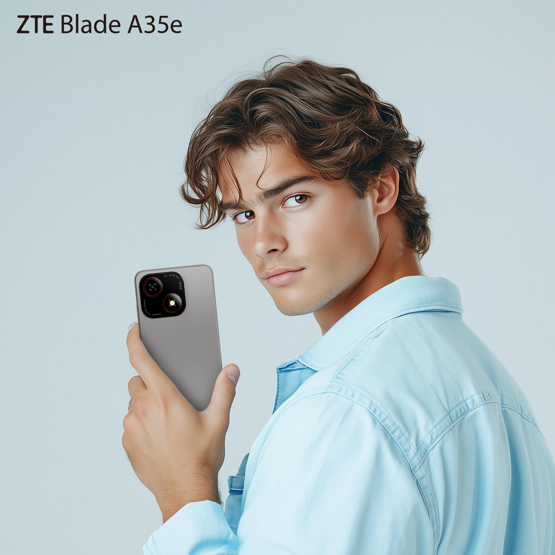 Mężczyzna w niebieskiej koszuli trzyma smartfon ZTE Blade A35e, pokazując widzowi stronę aparatu.