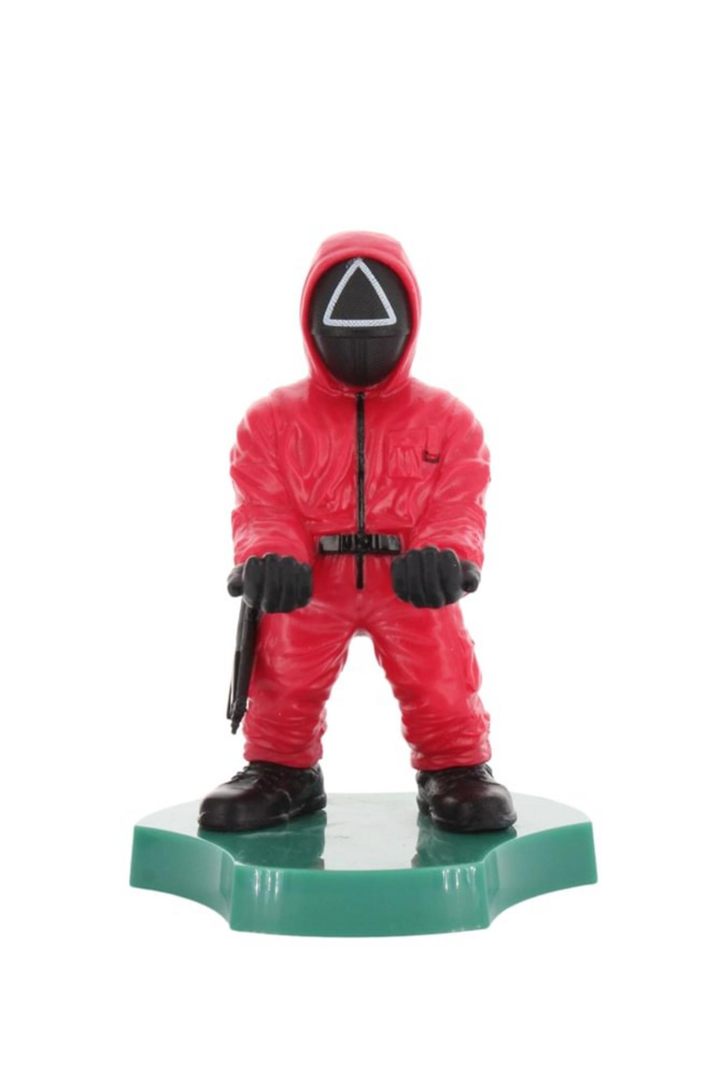 Eine rote Squid Game-Figur auf einem grünen Sockel, die eine Maske mit einem weißen Dreieck trägt.