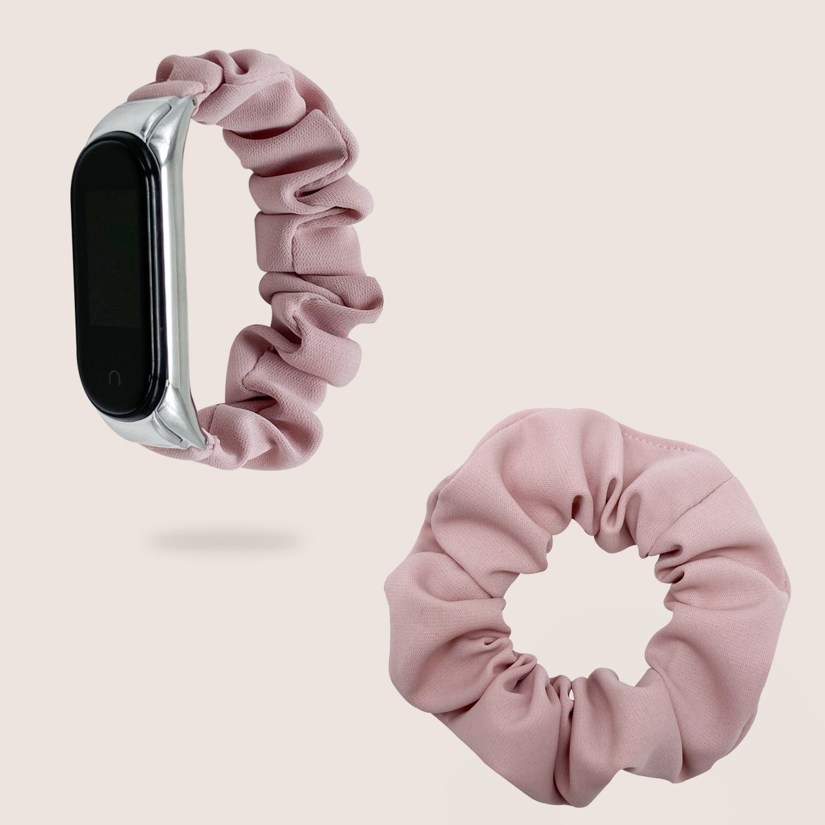 Zwei Gegenstände. Eine Smartwatch mit Scrunchie-Band und ein einzelnes passendes Scrunchie, beide pink.