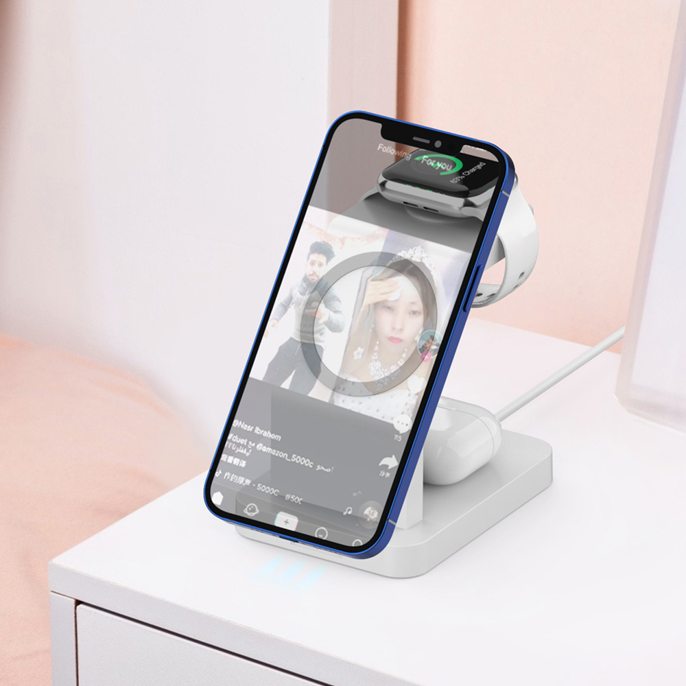 Ein Telefon, das auf einem weißen Ständer geladen wird, zeigt ein Video auf dem Bildschirm, mit Uhr und Ohrhörern.