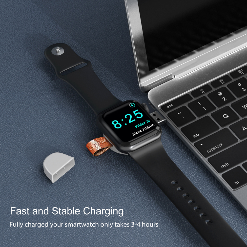 Apple Watch wird auf einem Tisch in der Nähe eines Laptops geladen, mit weißem Ladegerät.
