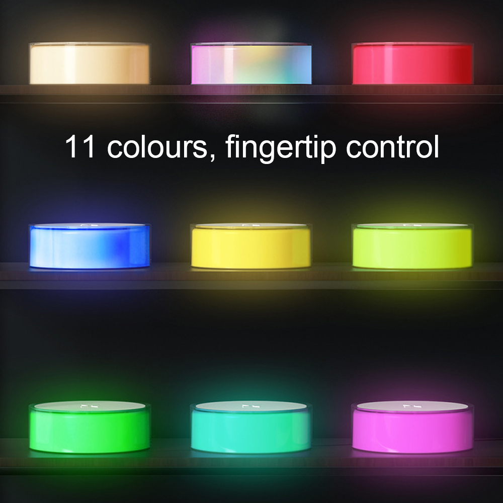 Ein Regal mit mehreren runden Geräten, jedes mit einer unterschiedlich farbigen Oberseite, beleuchtet. Der Text lautet: '11 Farben, Fingersteuerung'.