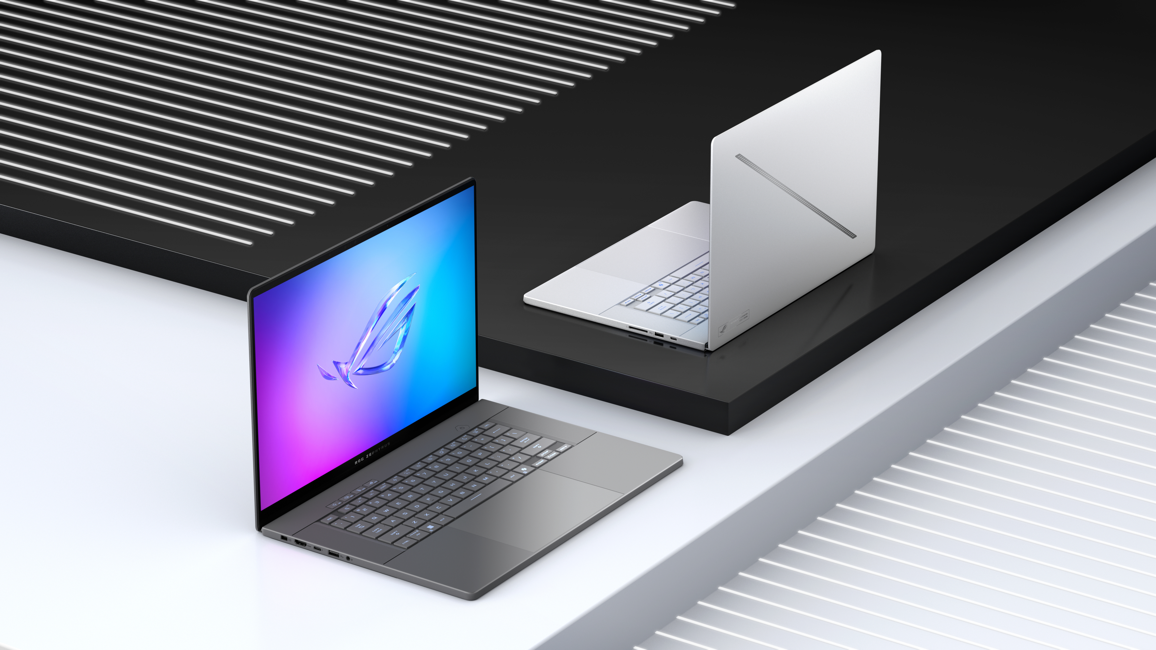 Zdjęcie przedstawia dwa laptopy, jeden otwarty z kolorowym ekranem, na nowoczesnej czarno-białej platformie.