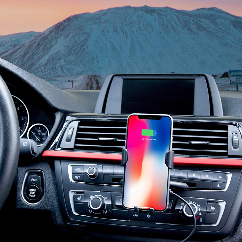Ein Smartphone ist in einer Autotelefonhalterung auf dem Armaturenbrett montiert und zeigt eine aufladende Batterie an.