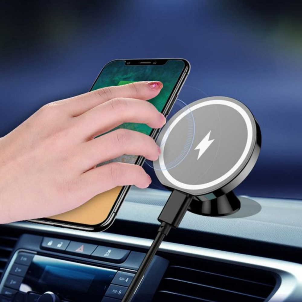 Eine Hand legt ein Telefon auf eine magnetische, kabellose Ladehalterung in einem Auto.