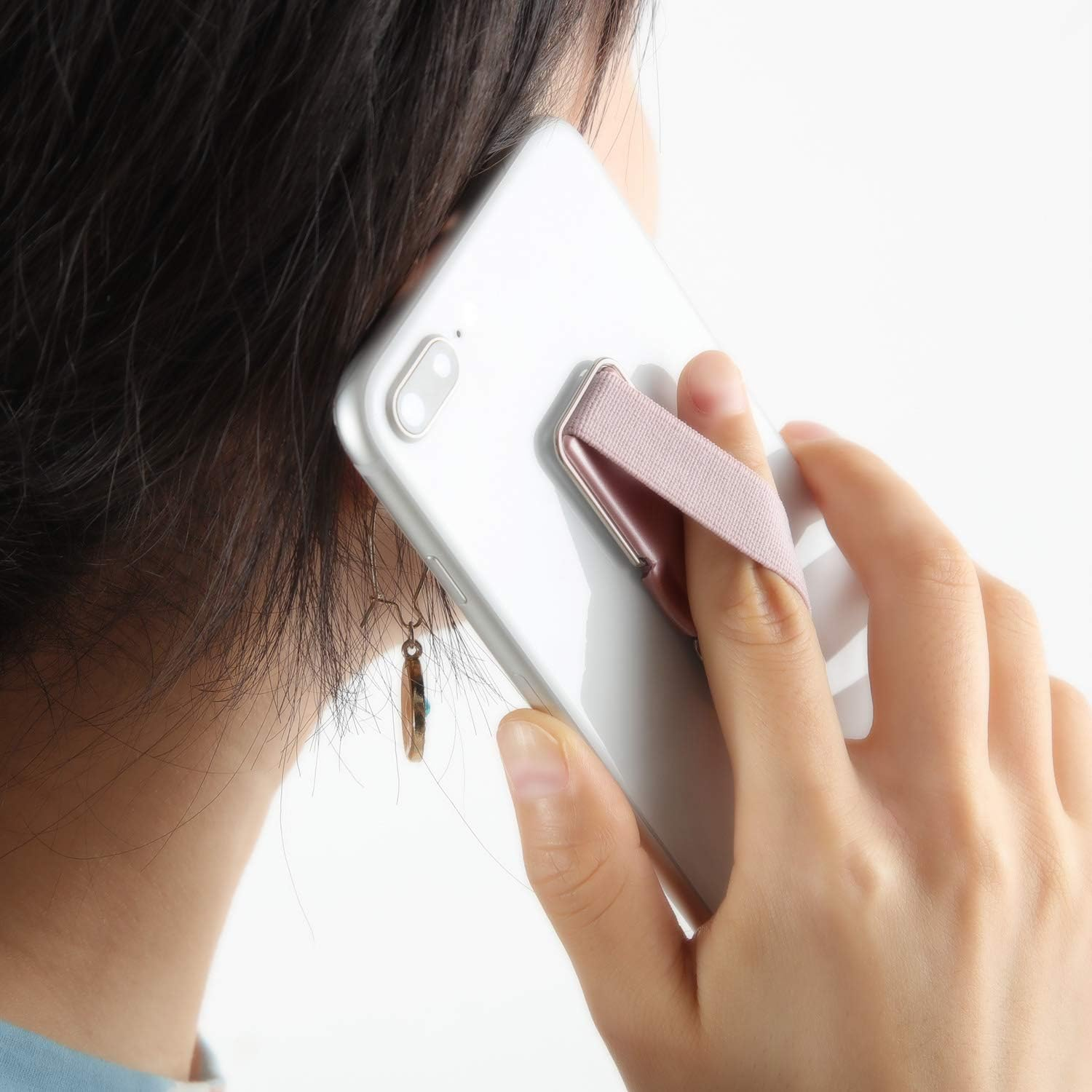 Person, die ein Telefon mit einem rosa elastischen Handgelenkband und einem Metallständer benutzt.