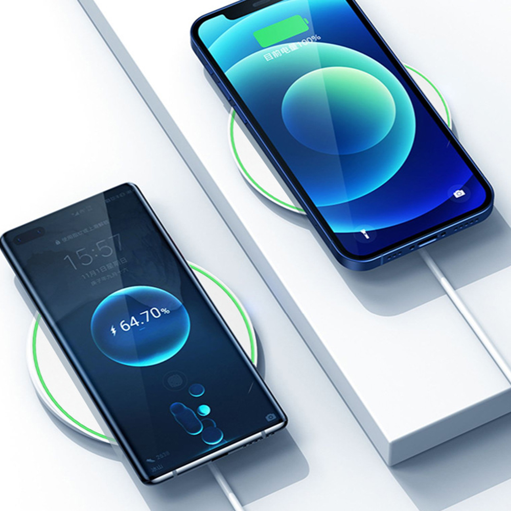 Zwei Smartphones laden kabellos auf weißen Pads und zeigen Ladeprozente auf ihren Bildschirmen an.