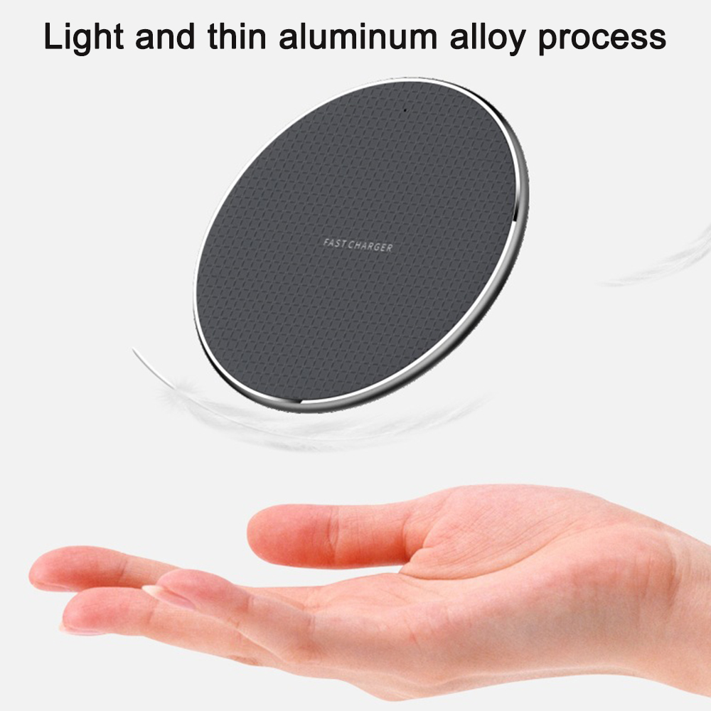 Eine Hand hält ein graues kabelloses Ladepad und betont sein leichtes und dünnes Design.