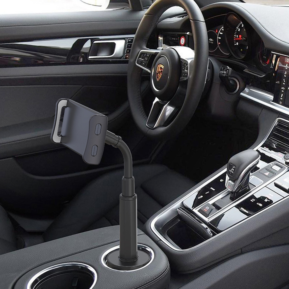 Ein Telefonhalter befindet sich im Getränkehalter eines Autos. Das Innere des Autos ist sichtbar, einschließlich des Lenkrads.