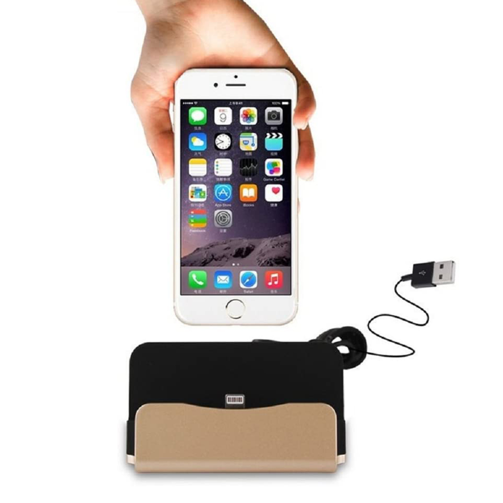 Eine Hand hält ein Smartphone über eine Ladestation; ein USB-Kabel mit einem Ladestecker ist sichtbar.