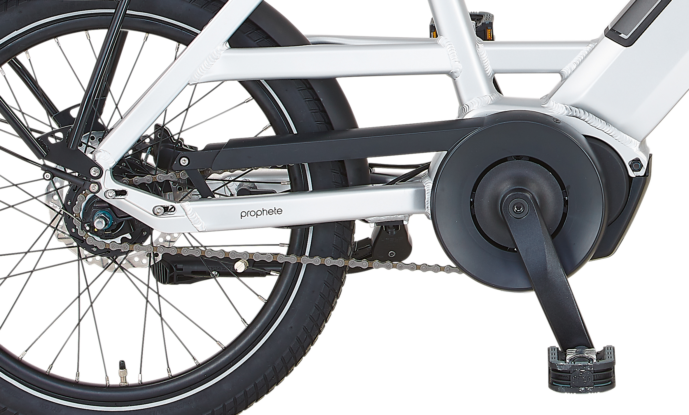 Prophete E-Bike Antriebsstrang Detail: silberner Rahmen, schwarzer Kettenschutz, Pedal und Hinterrad auf Weiß.